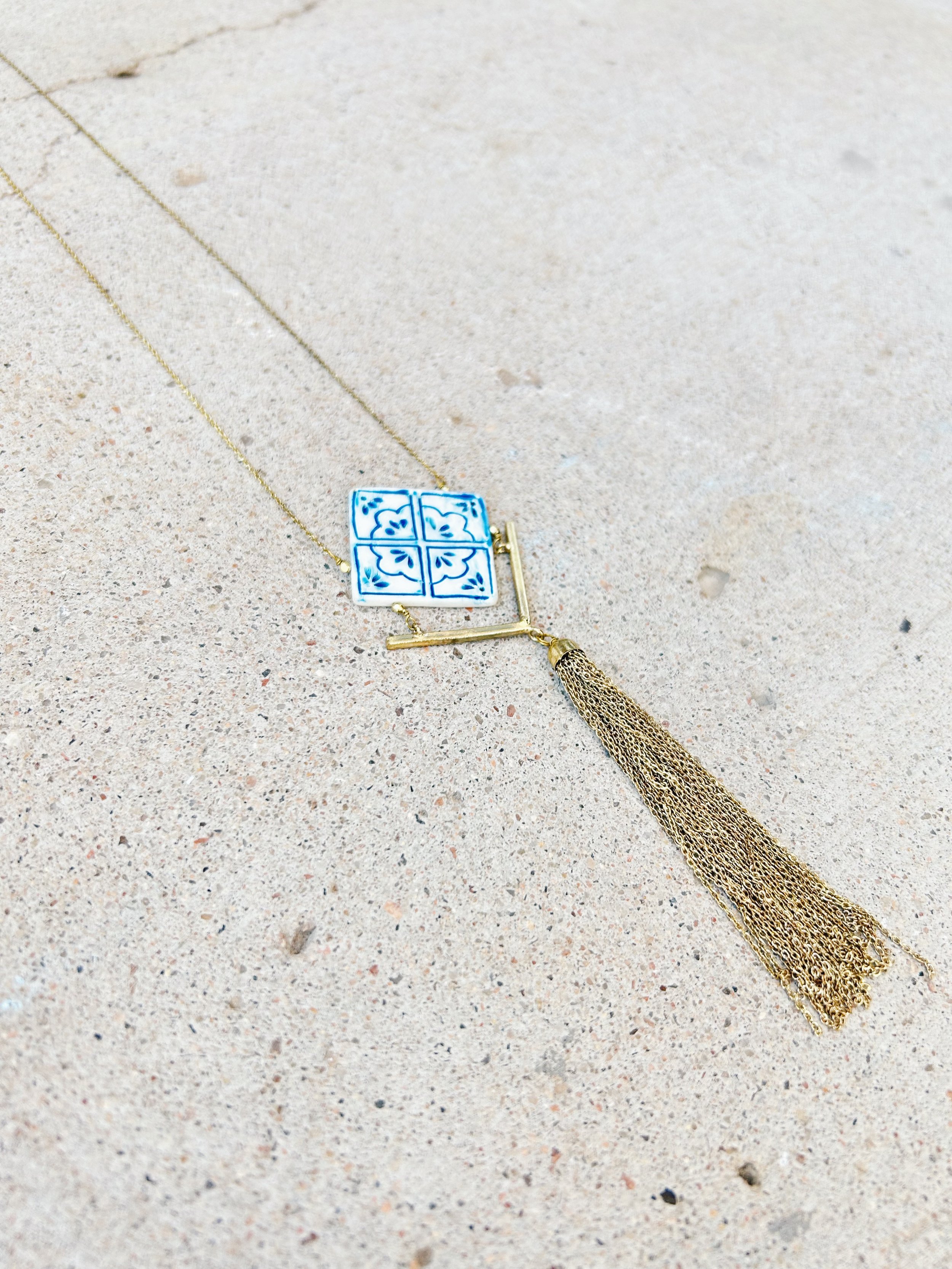 Each Mallorca Tile Necklace has an up-cycled white bone tile in a diamond shape. This tile is hand-painted with blue designs.