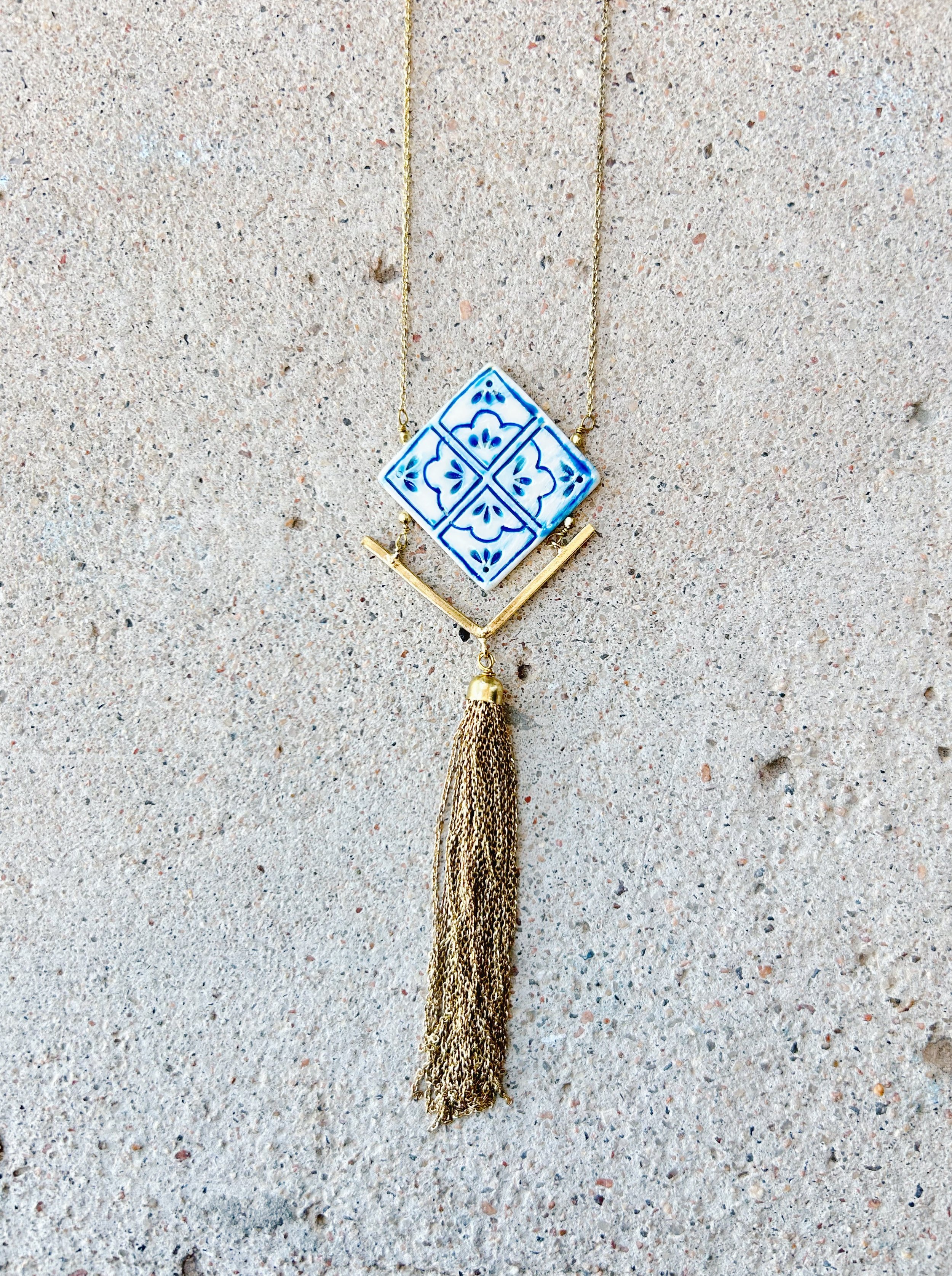 The Mallorca Tile Necklace tile pendant is accented with a brass tassel detail.