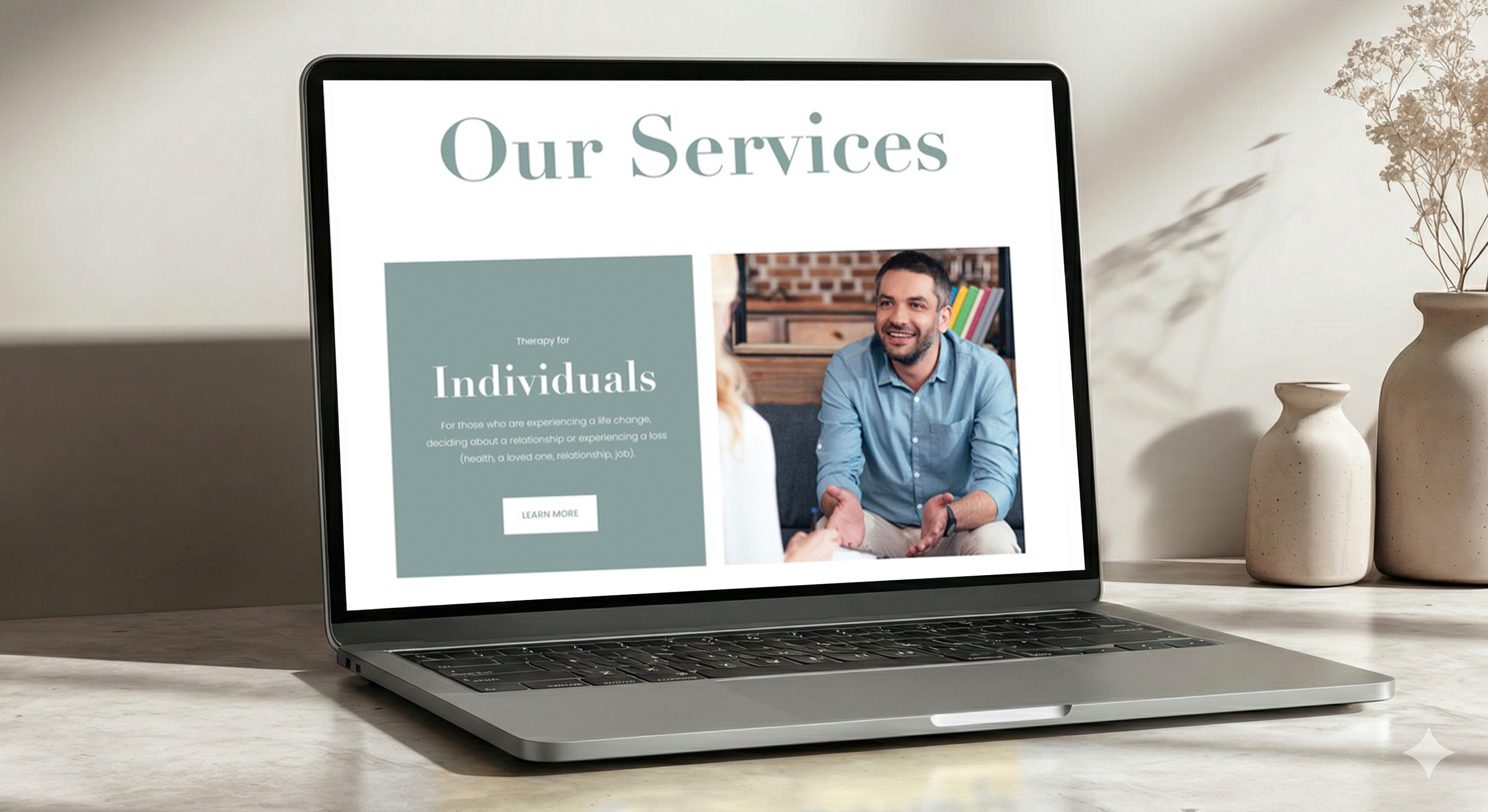 Laptop on a table displaying a website with the heading 'Our Services' and a section about therapy for individuals, with a photo of a man smiling and talking to a woman.