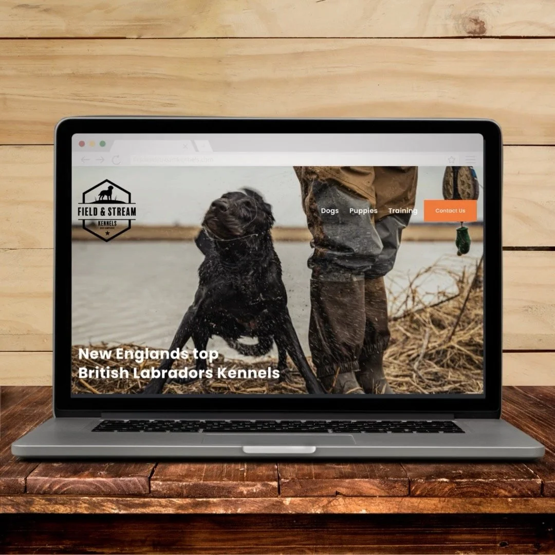 Laptop displaying a dog training website with a picture of a person and a black Labrador retriever near a body of water.
