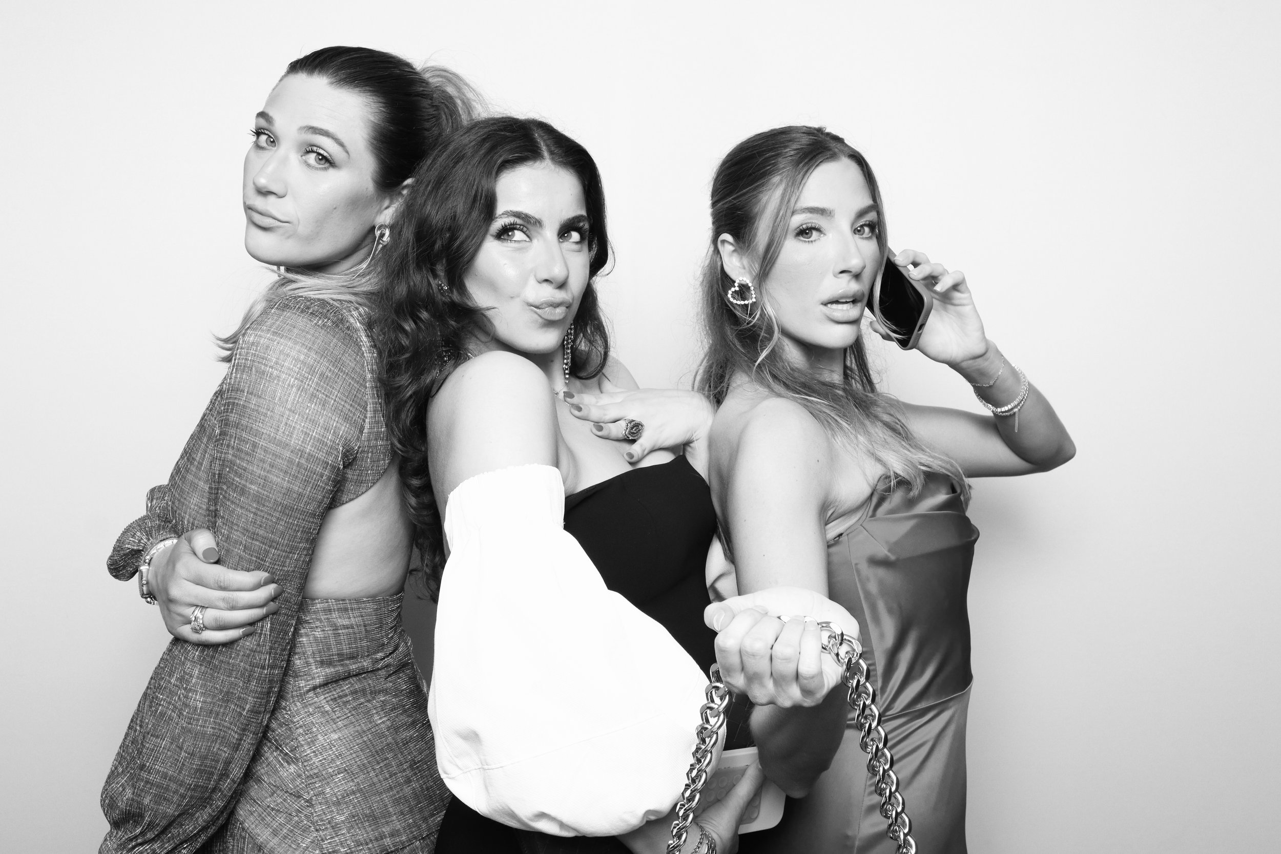 A group of girls at a wedding in Lafayette use our photo booth to take a black and white pic in front of our white backdrop.