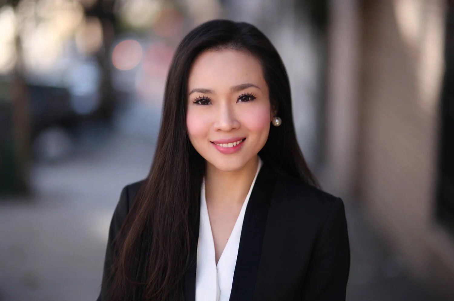 Professional headshot with natural lighting and an outdoor background