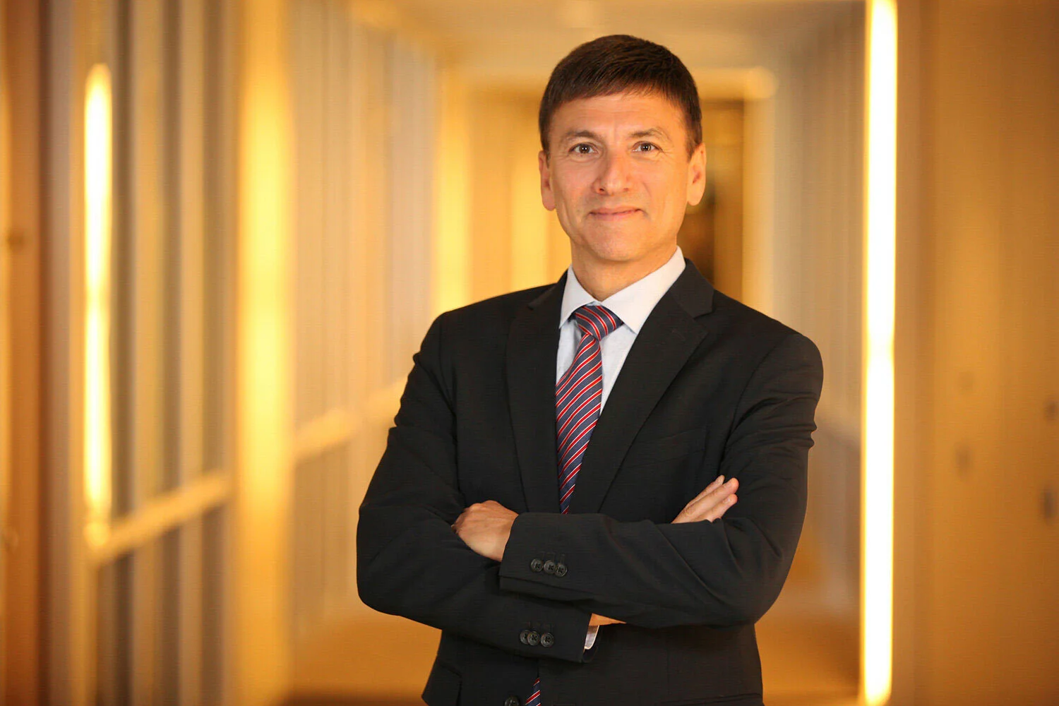 Man posing for headshot with bright golden background