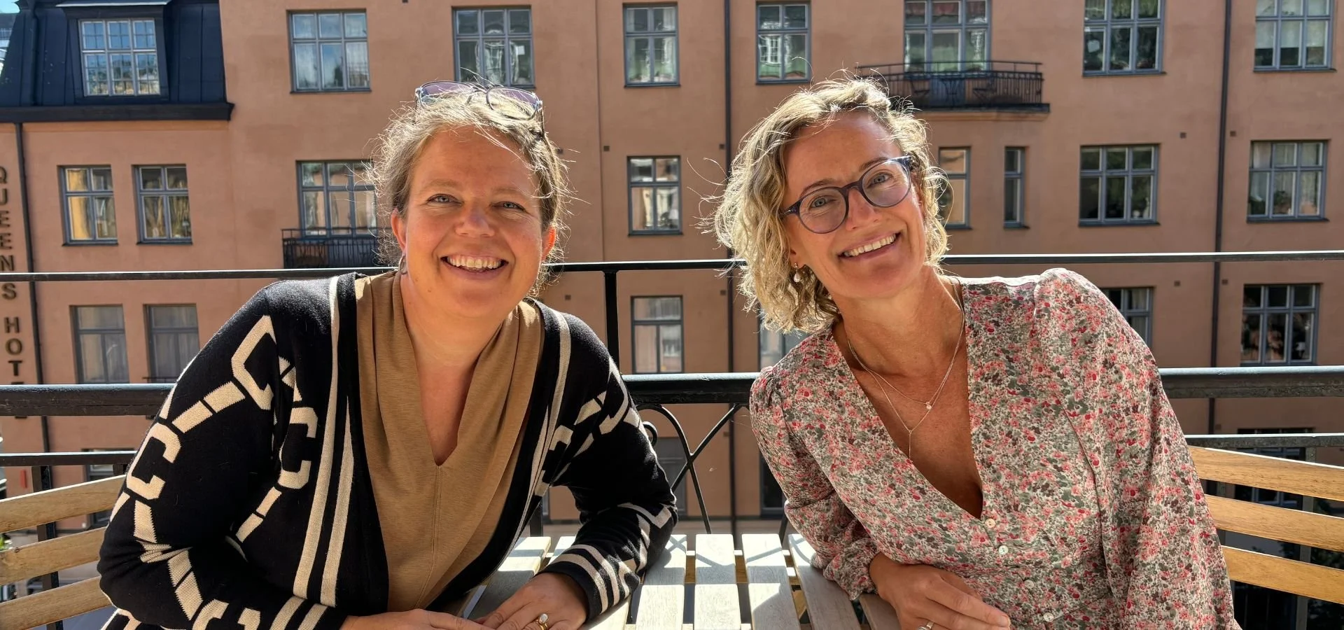 Laila och Annika sitter på en balkong och kollar in i kameran. De arbetar med utbildning inom konflikthantering.