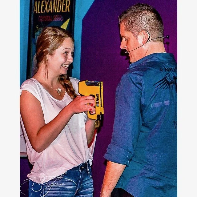 She's way too eager to blast me with a staple gun — like, unsettlingly happy about it.