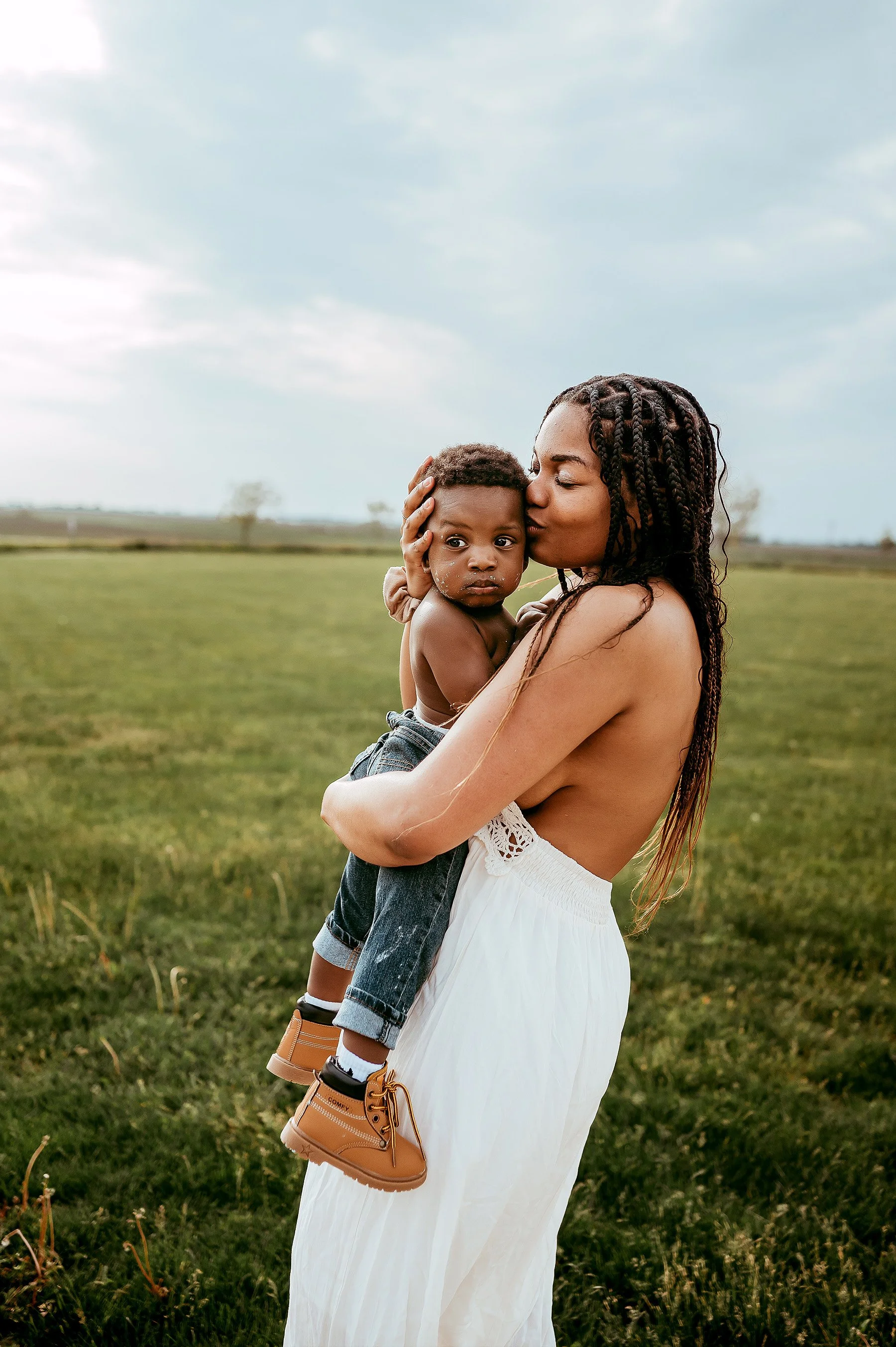 Mom embracing one year old after cake smash birthday celebration