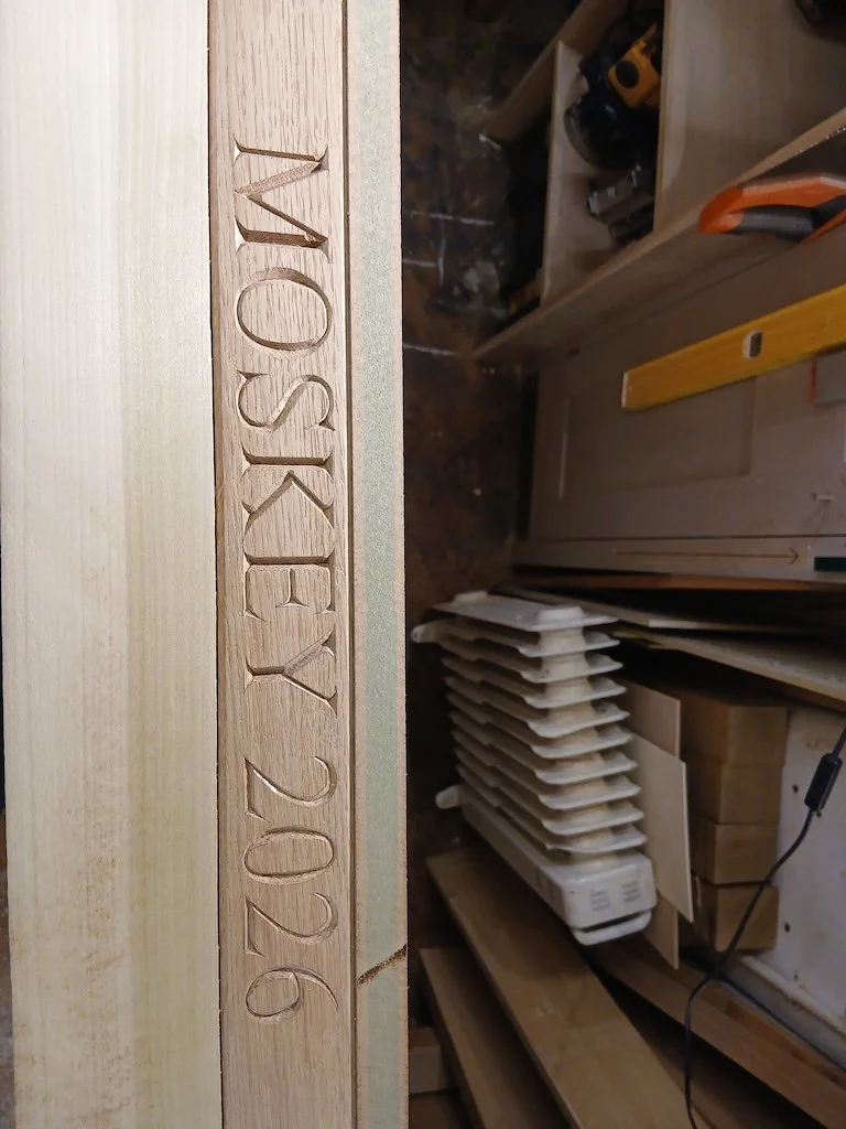 Lettering carved into the edge of a 5 metre long oak refectory table