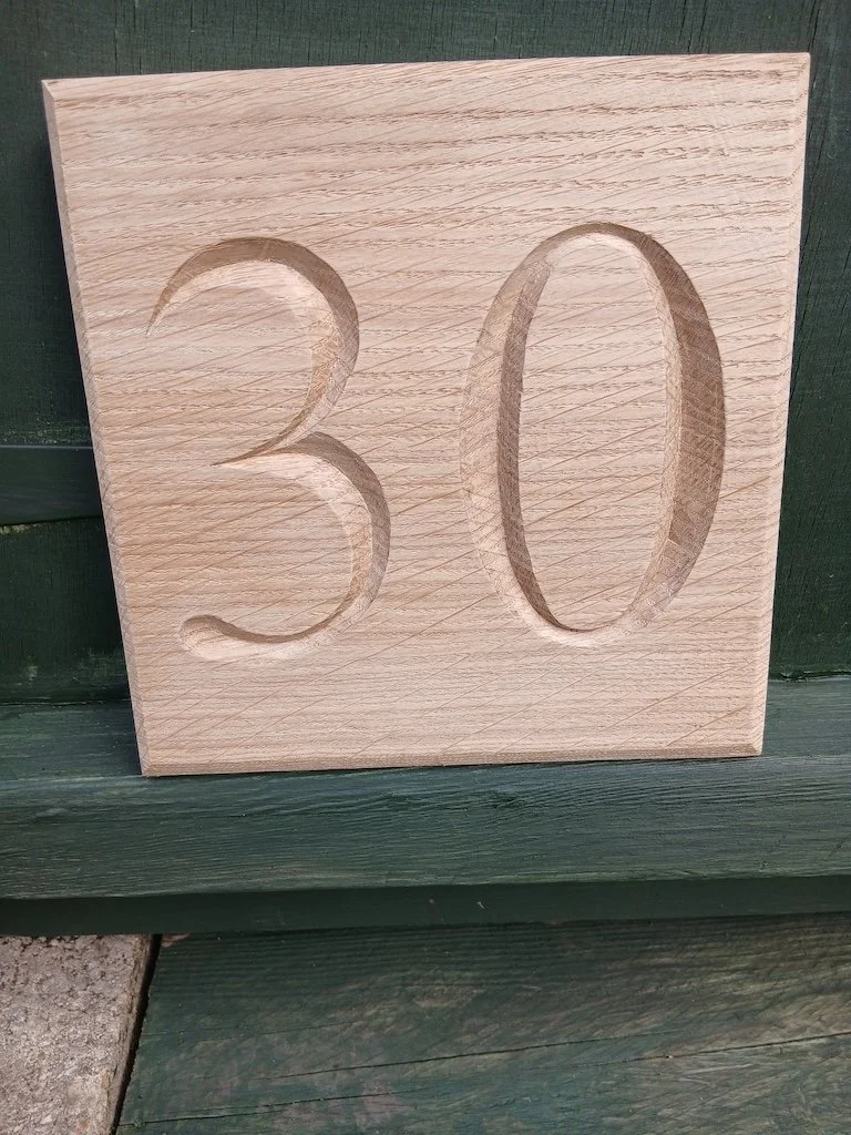 A house number carved into oak for a renovated cottage