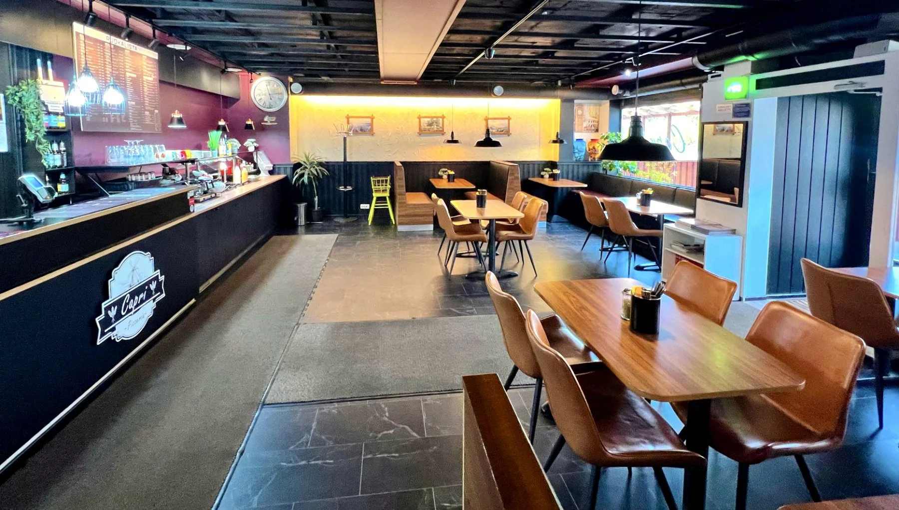 Ravintola sisältä päin kuvattuna, vasemmalla tiski ja viininpunainen seinä.