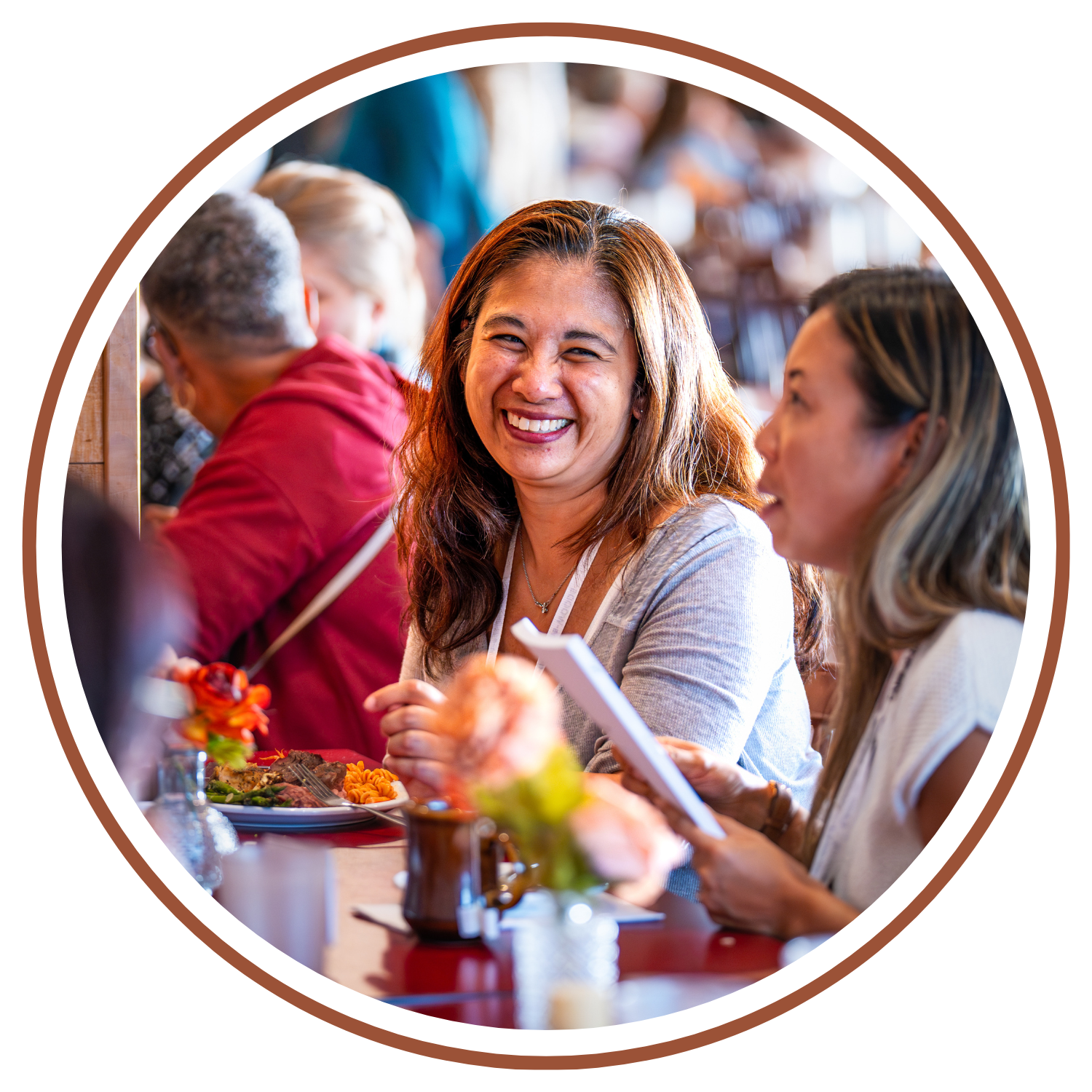 Women laughing and eating together at CAMP-of-the-WOODS dining hall