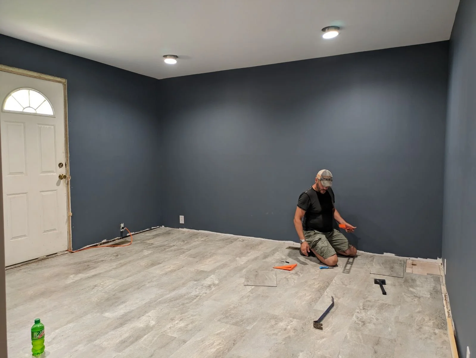 Man installing floor in blue room