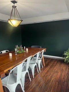Dining room with green-toned walls before a full design makeover