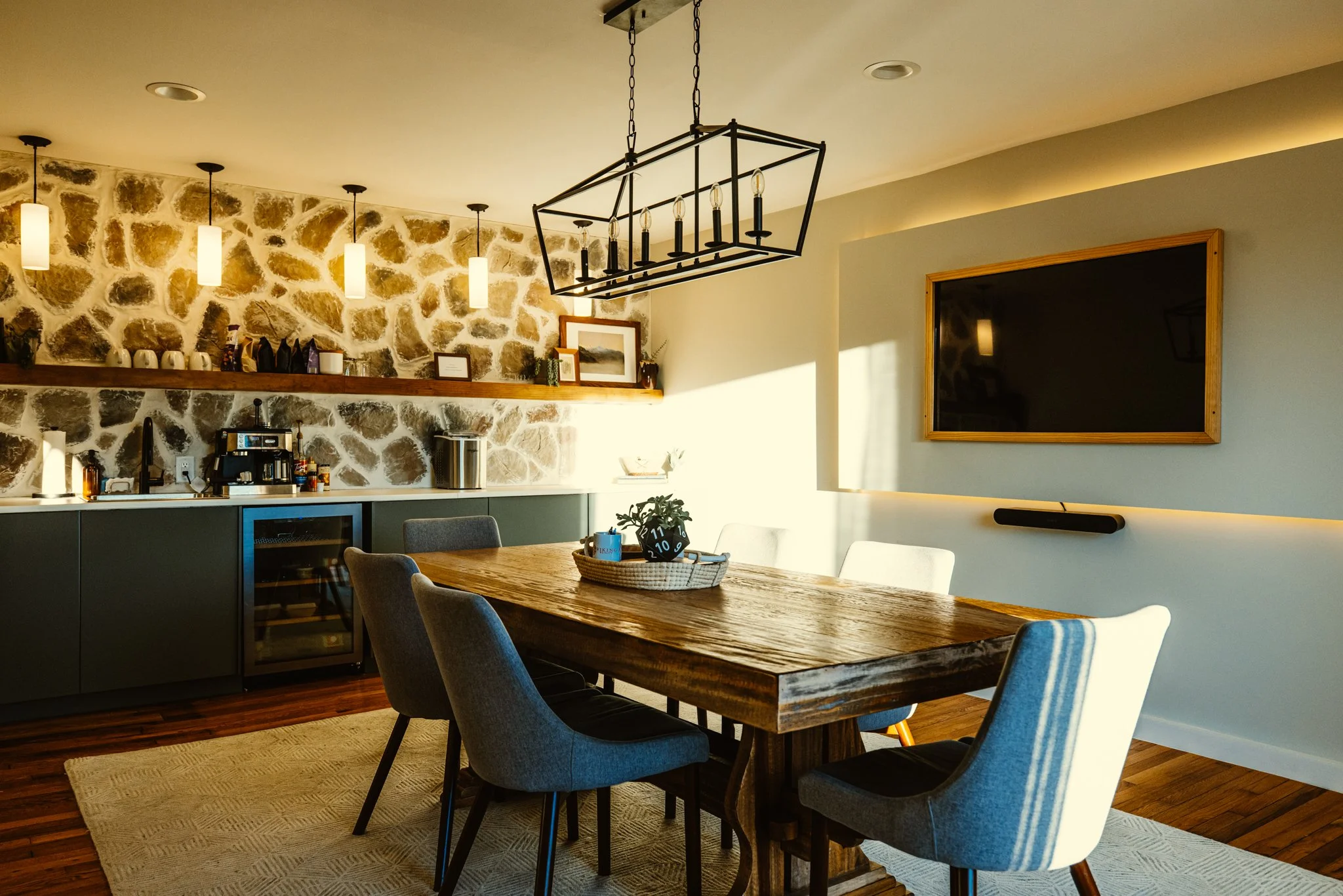Rustic conference room with wood table, stone wall, and chandelier