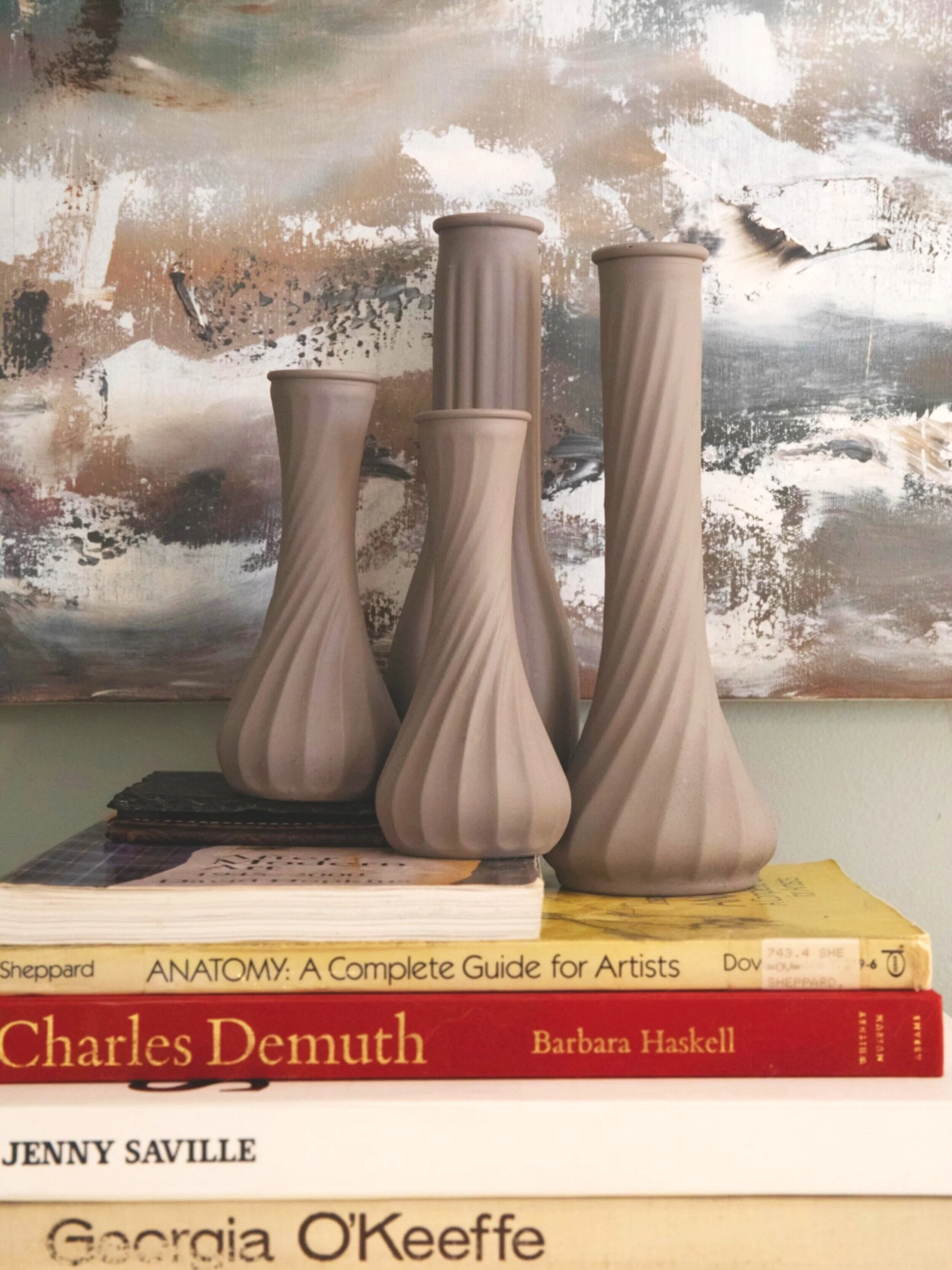 Four_Mink-colored_vases_on_stack_of_books-min.jpg