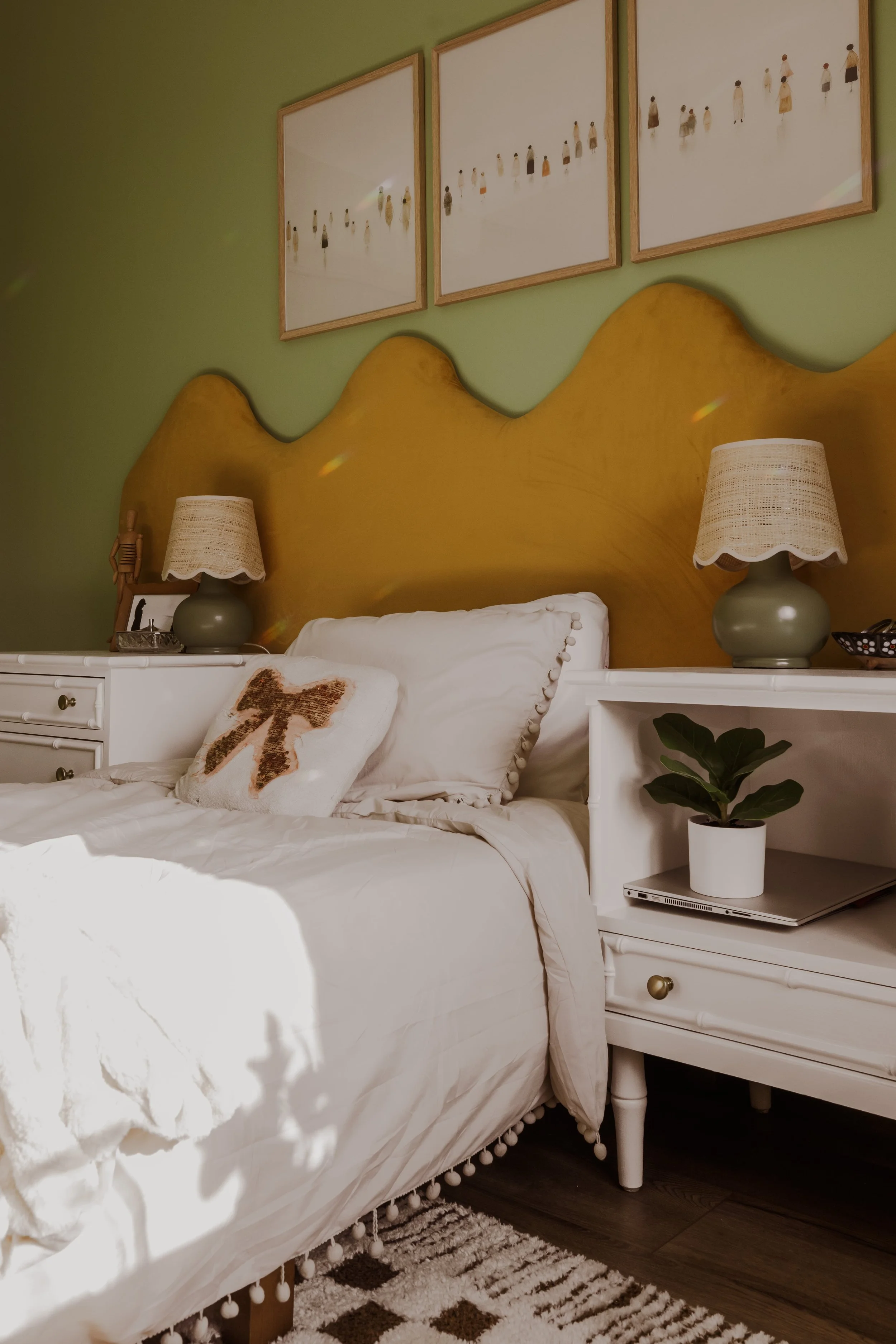 Close-up of wavy mustard velvet headboard against green wall
