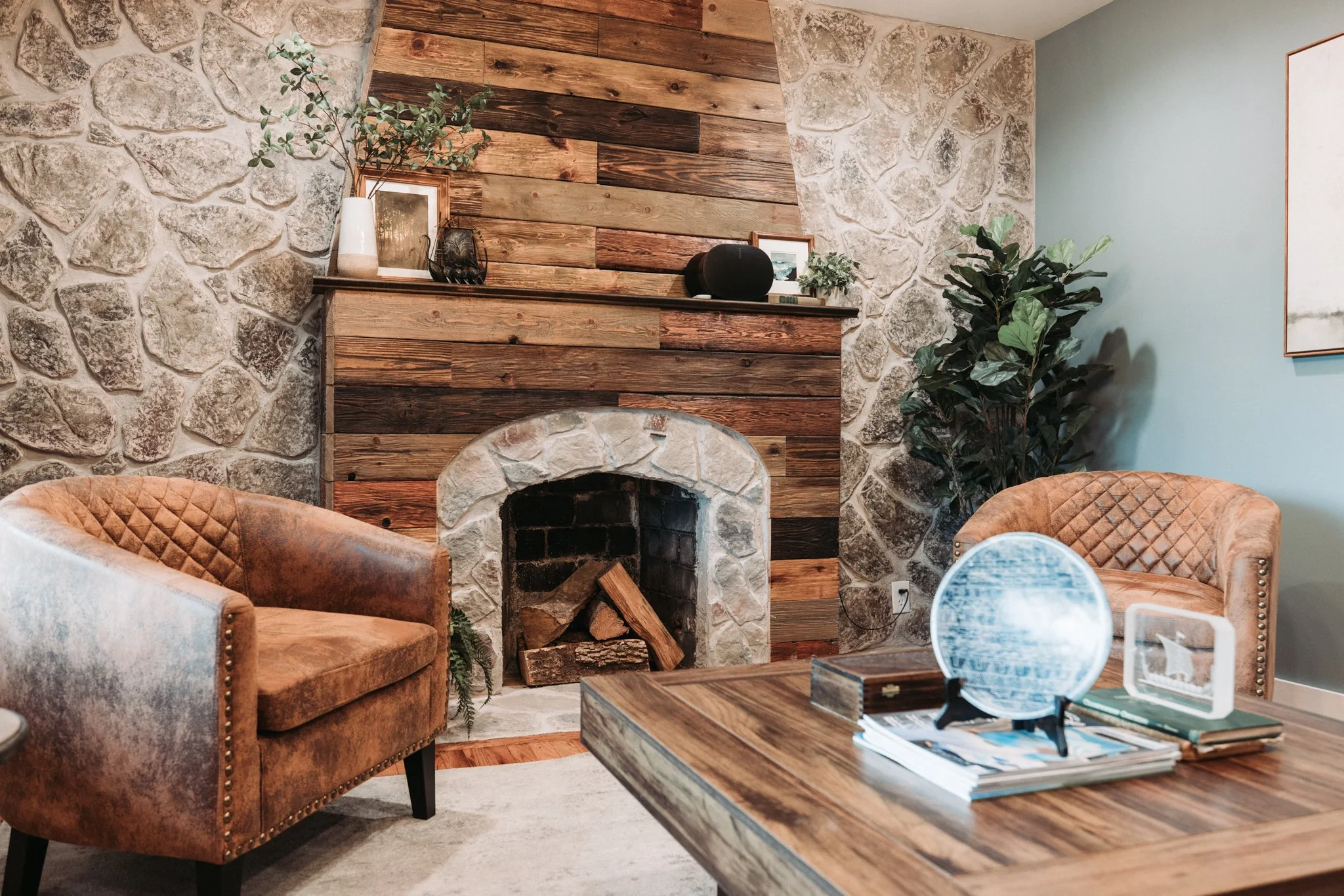 Close-up of wood and stone fireplace with styled mantel