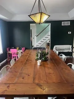 Dining room with green-toned walls before a full design makeover