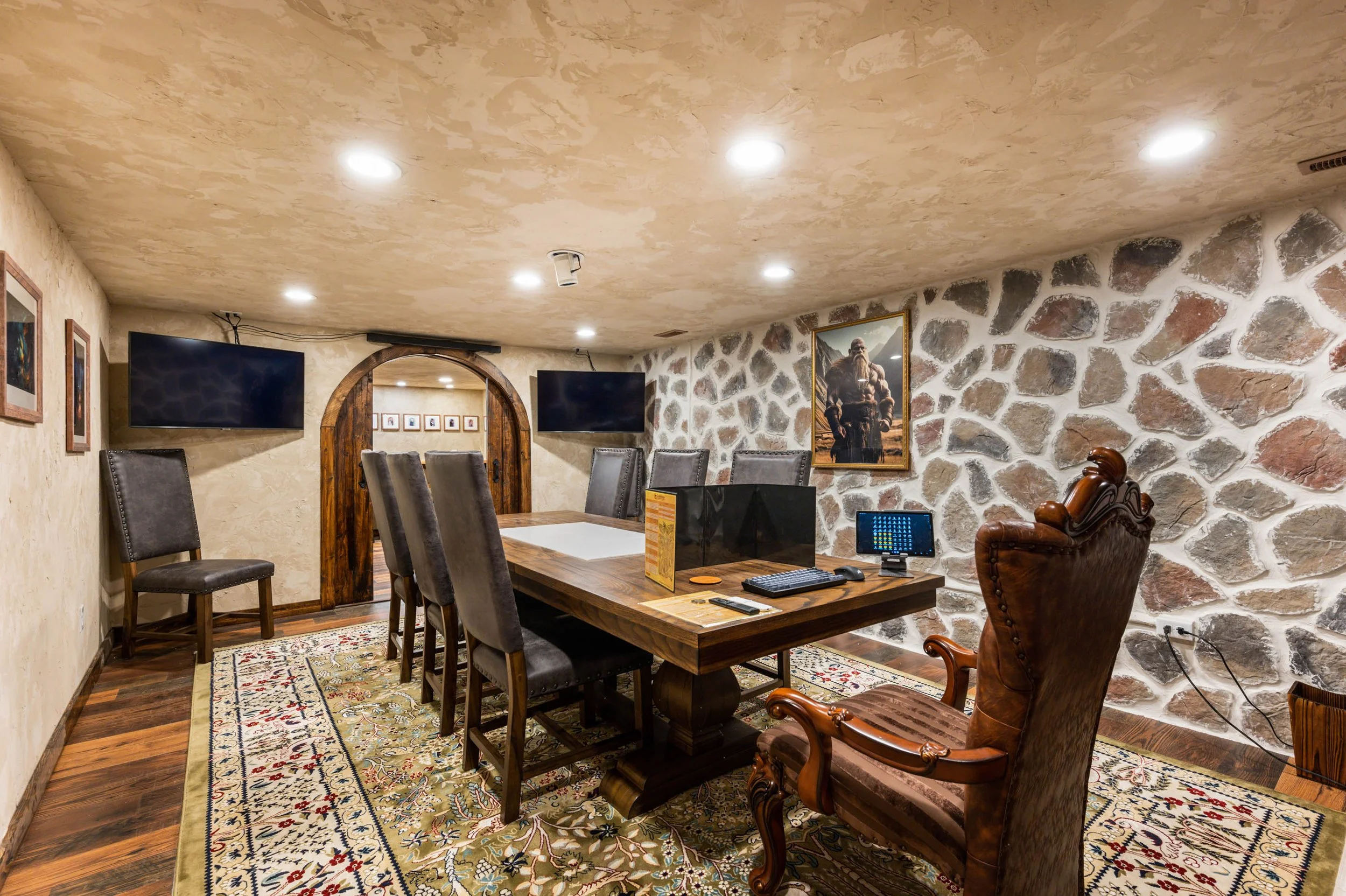 D&D game room with wall-mounted monitors and long table