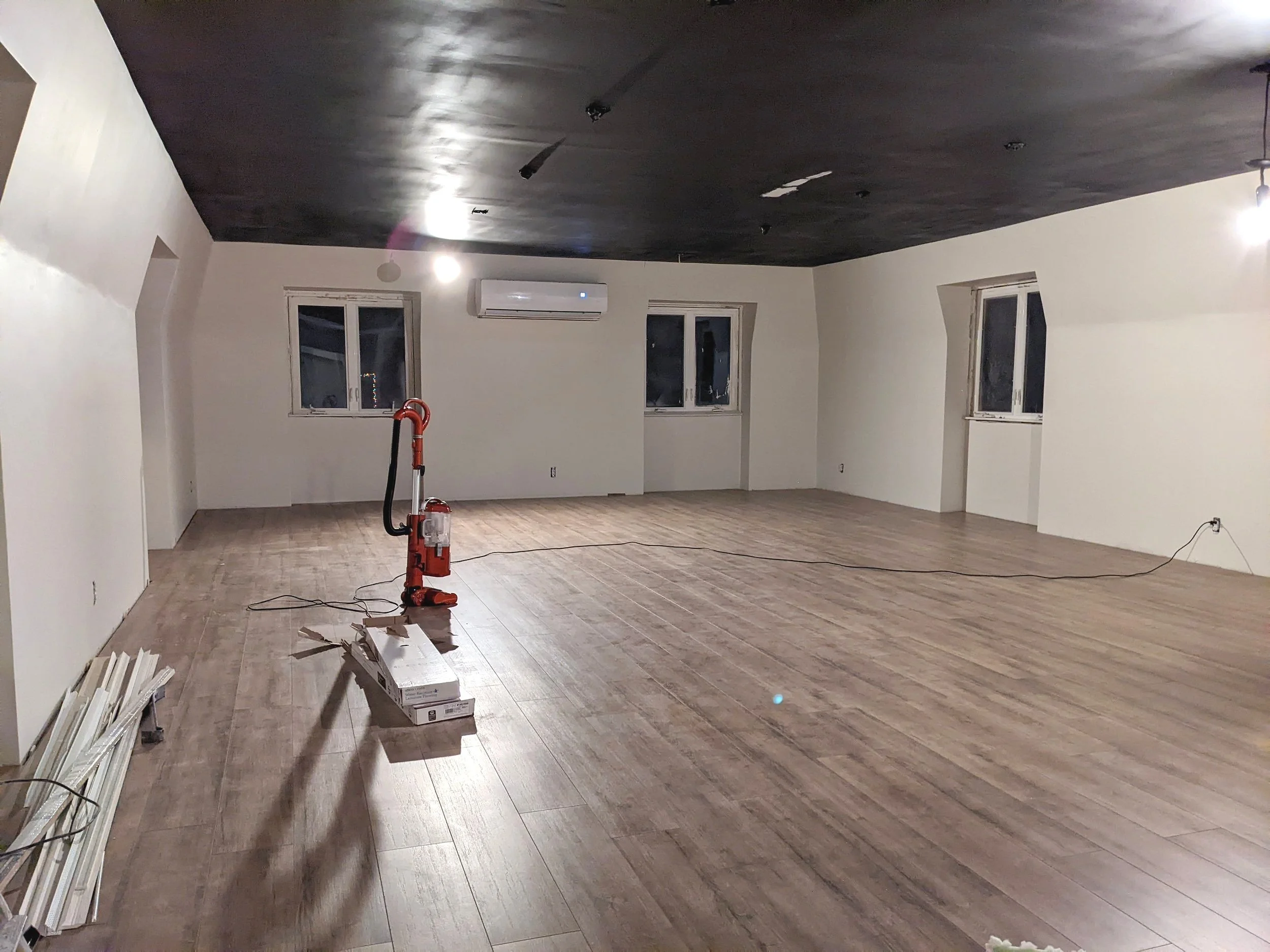 Empty rec room with black ceiling and white walls