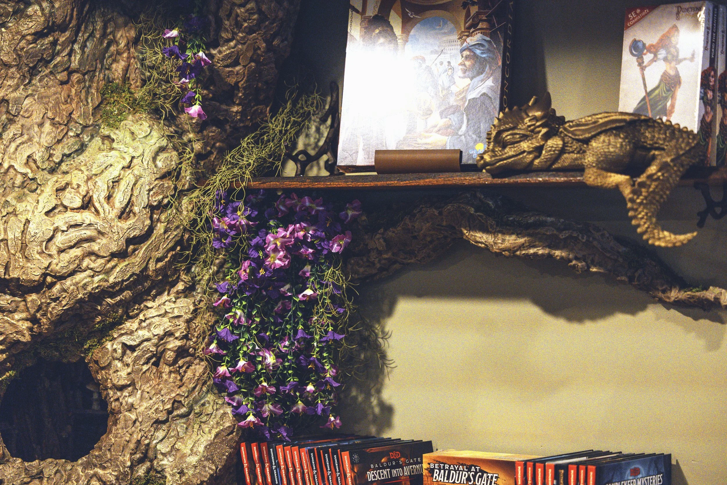 Close-up of fantasy tree trunk with moss, flowers, and D&D book display