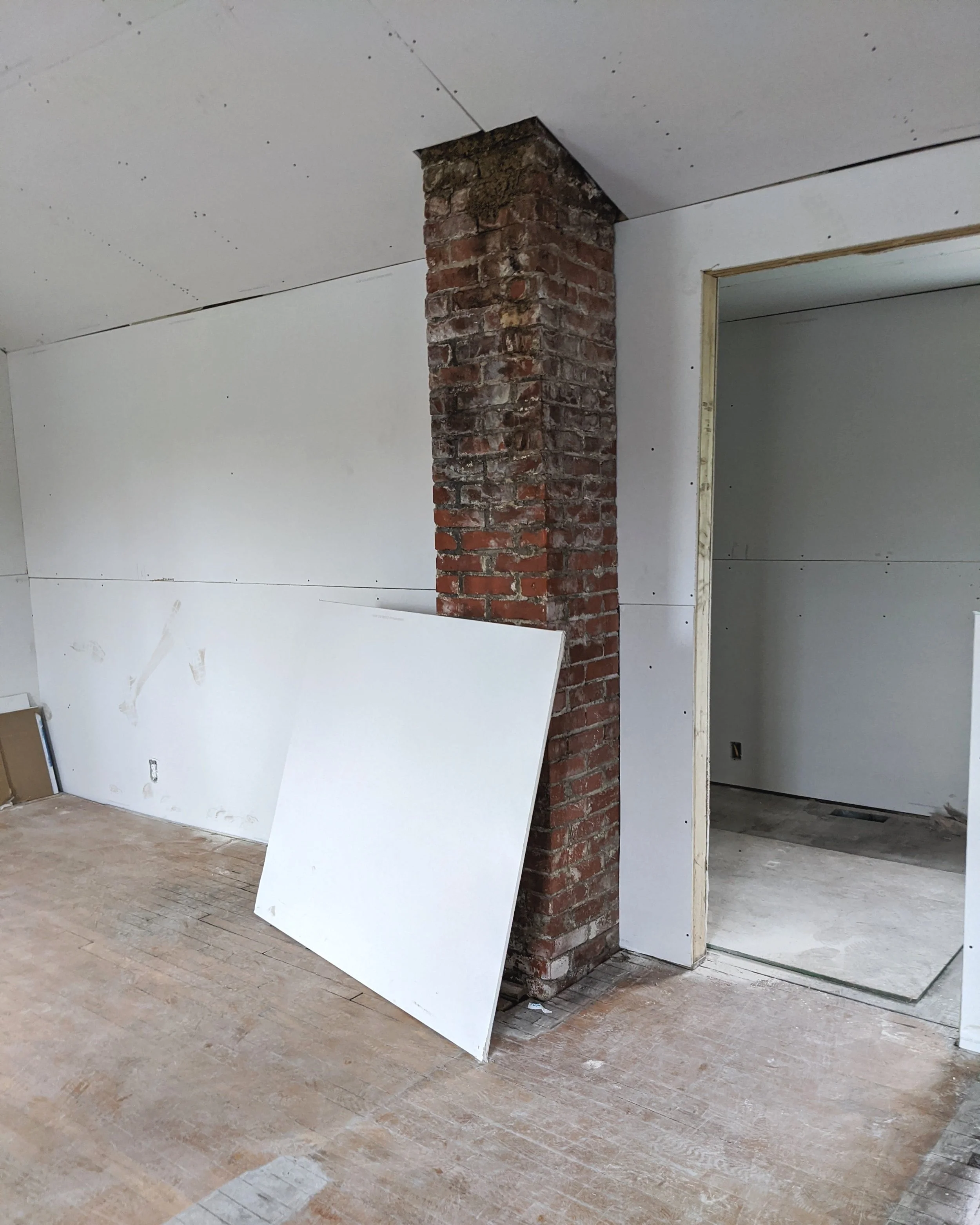 Exposed brick chimney unfinished drywall