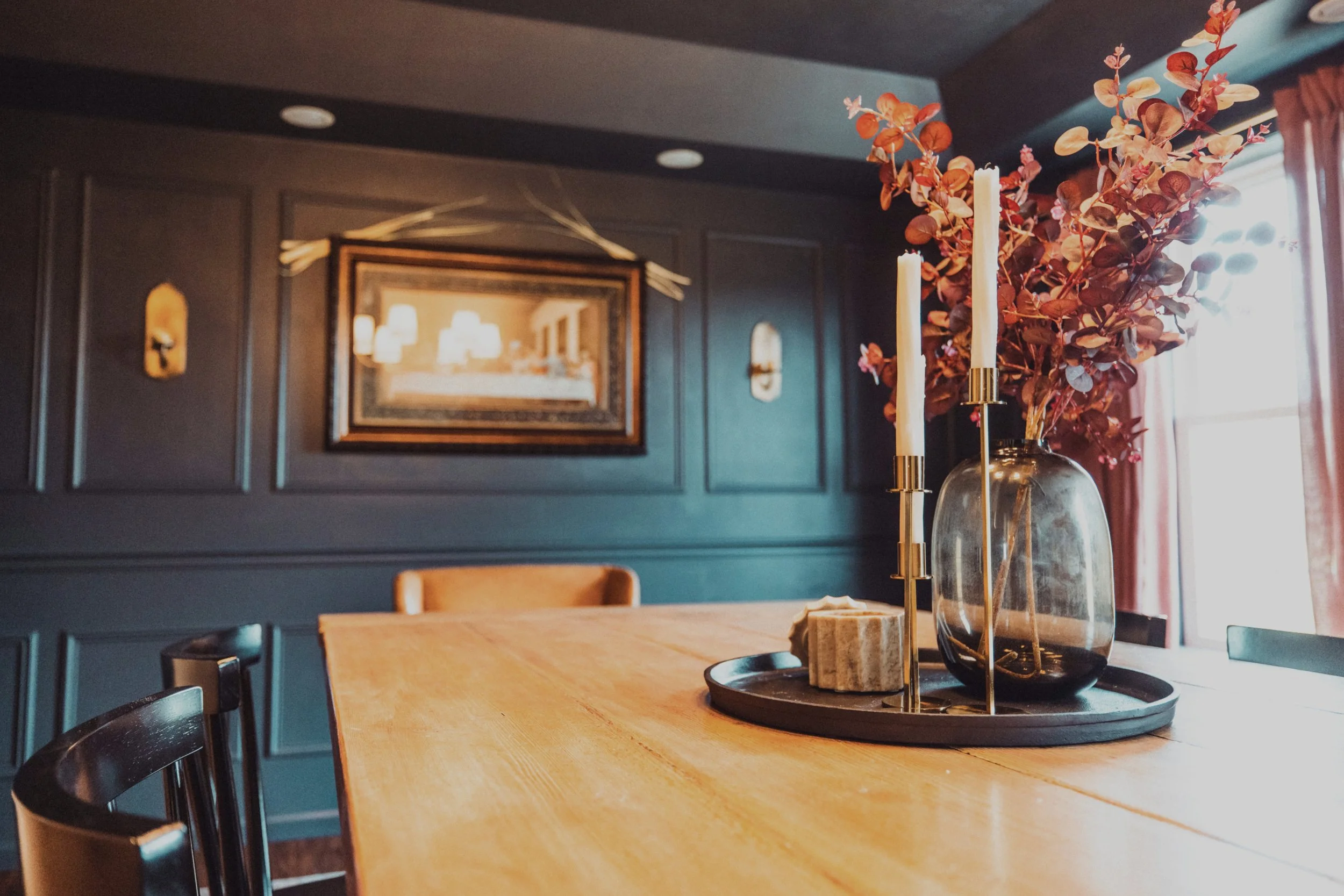 Brass candlesticks and smoked glass vase on wood dining table
