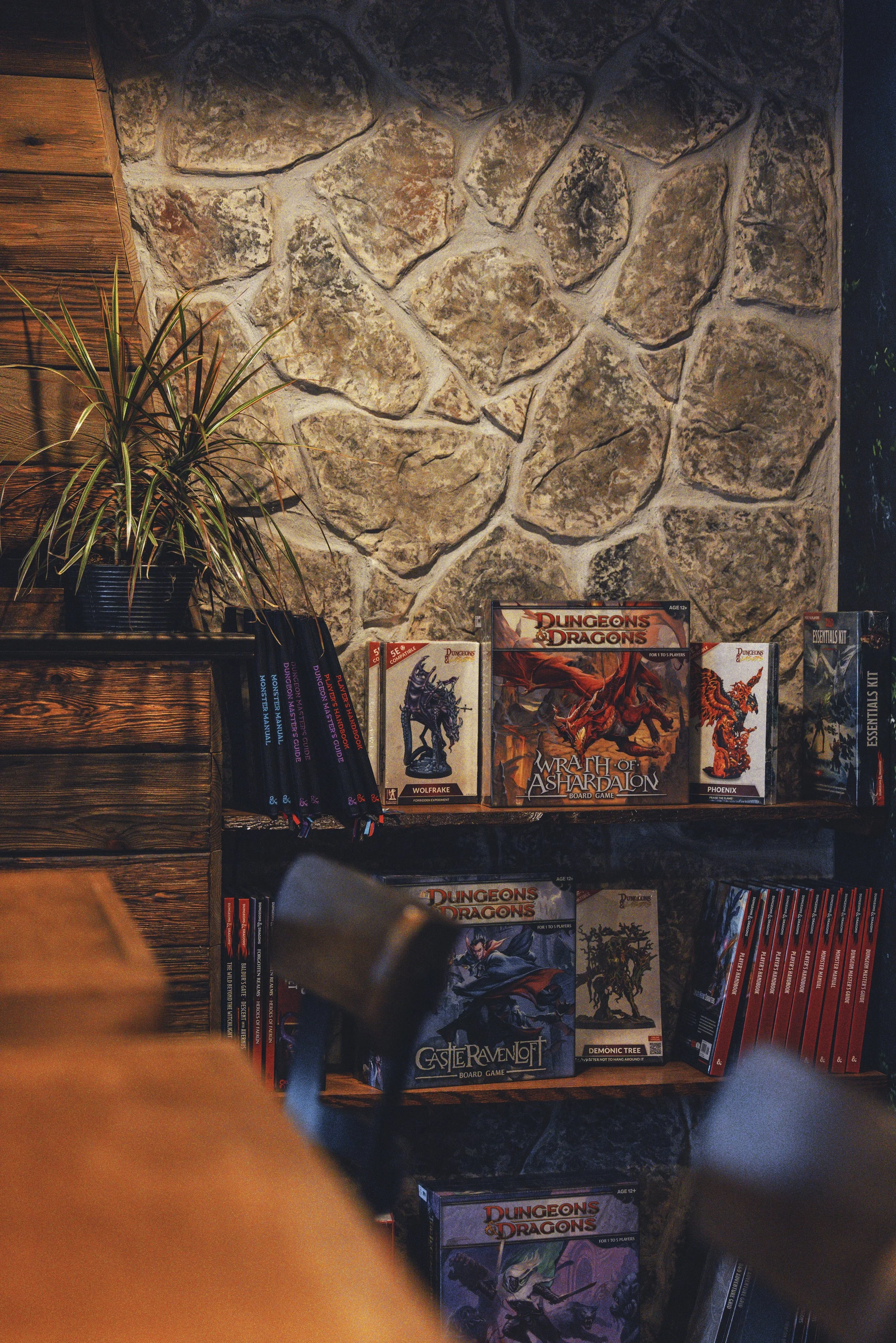 Stone accent wall styled with Dungeons and Dragons board games and books