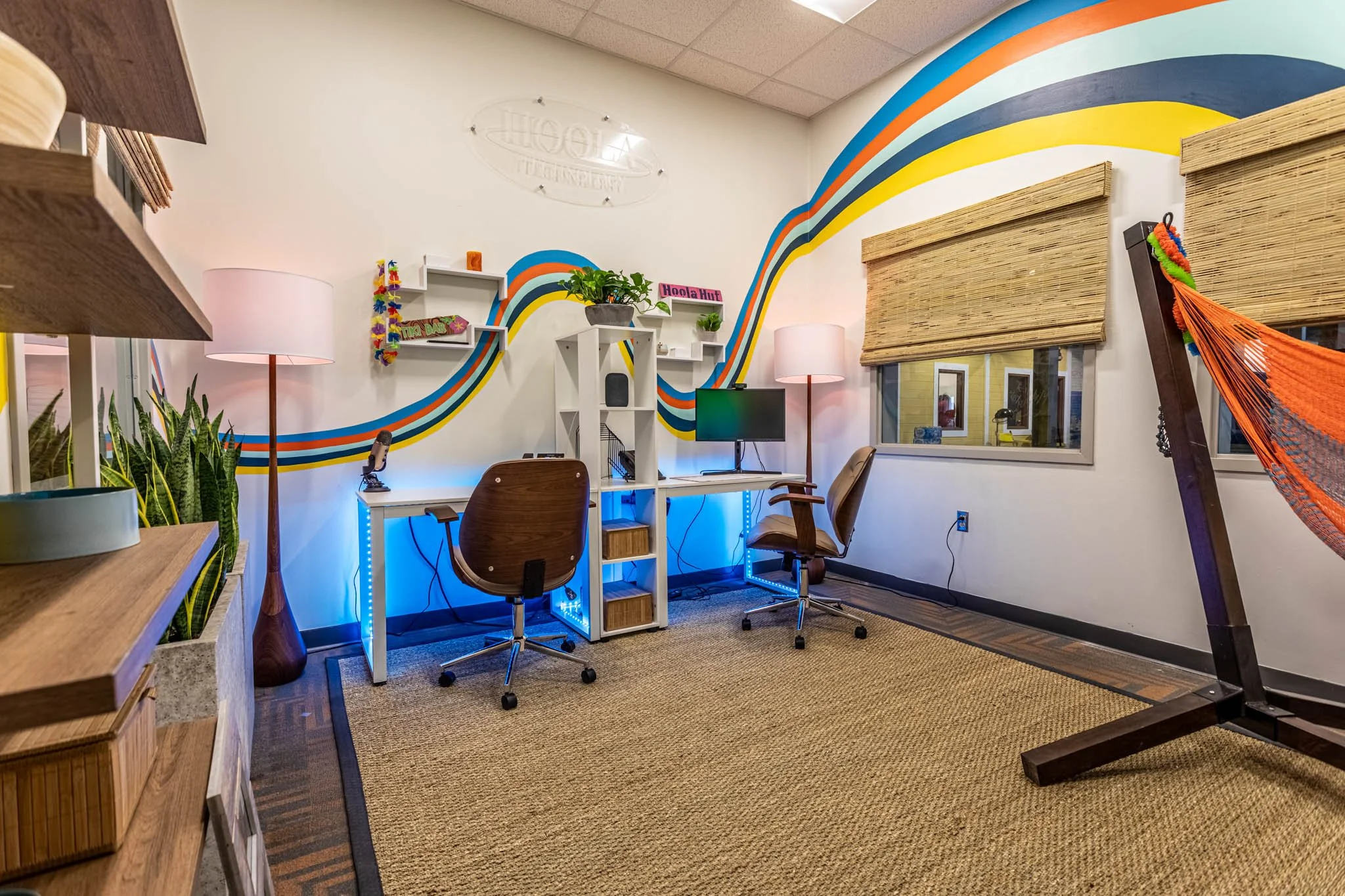 Office corner with orange hammock and colorful wave mural