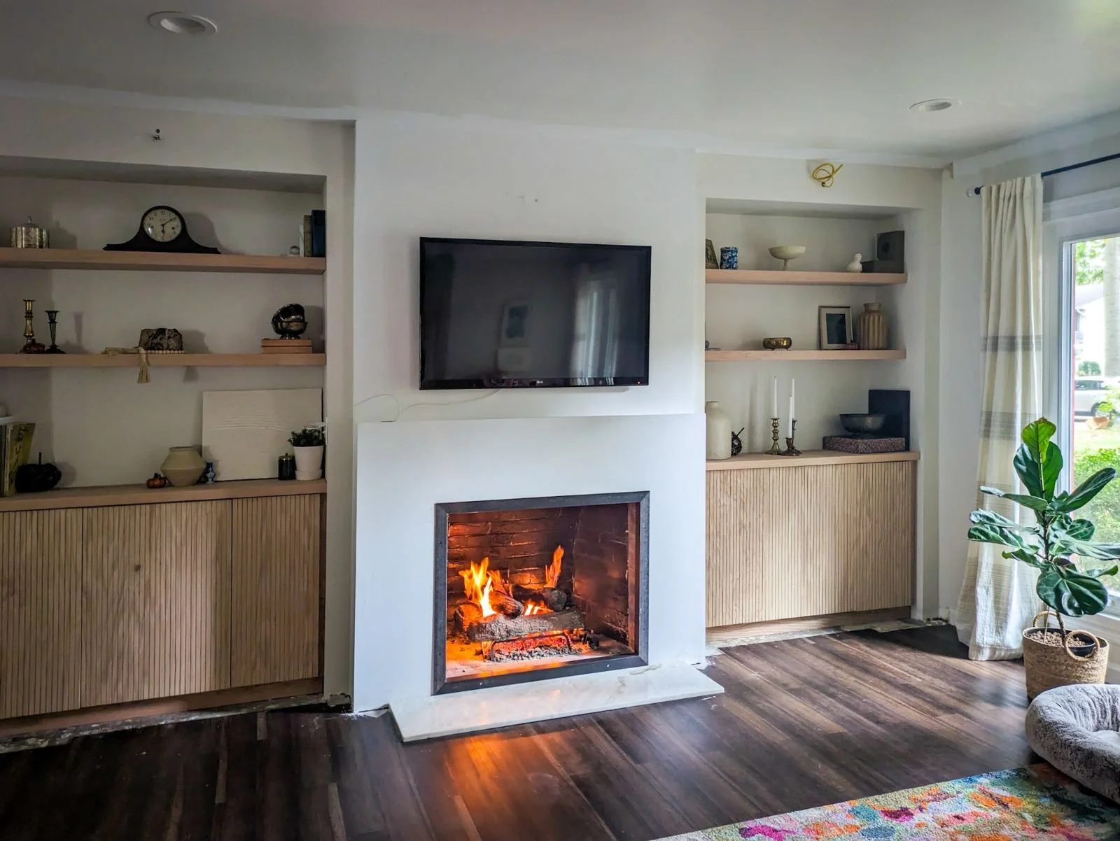 Modern fireplace wall with built-in cabinets and shelves on either side