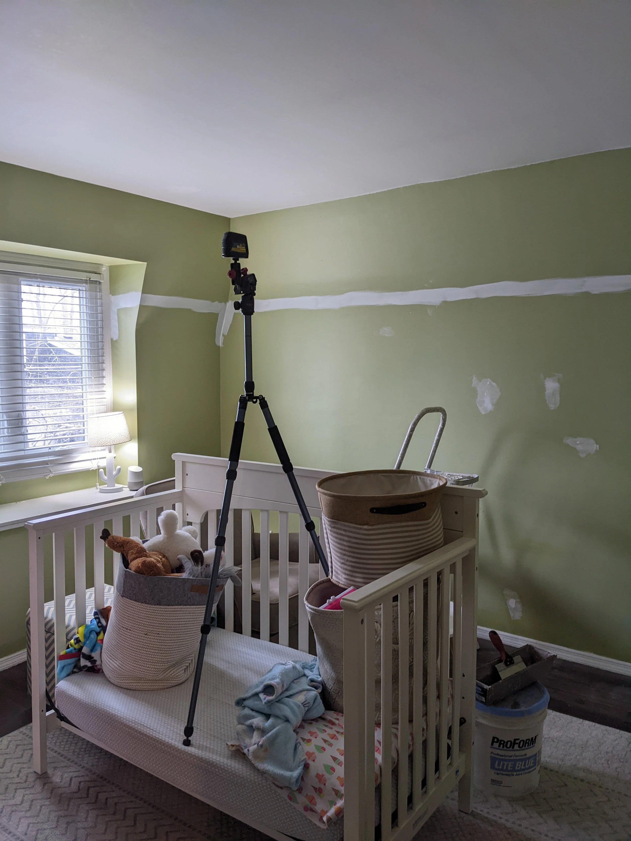 tripod on bed in green room
