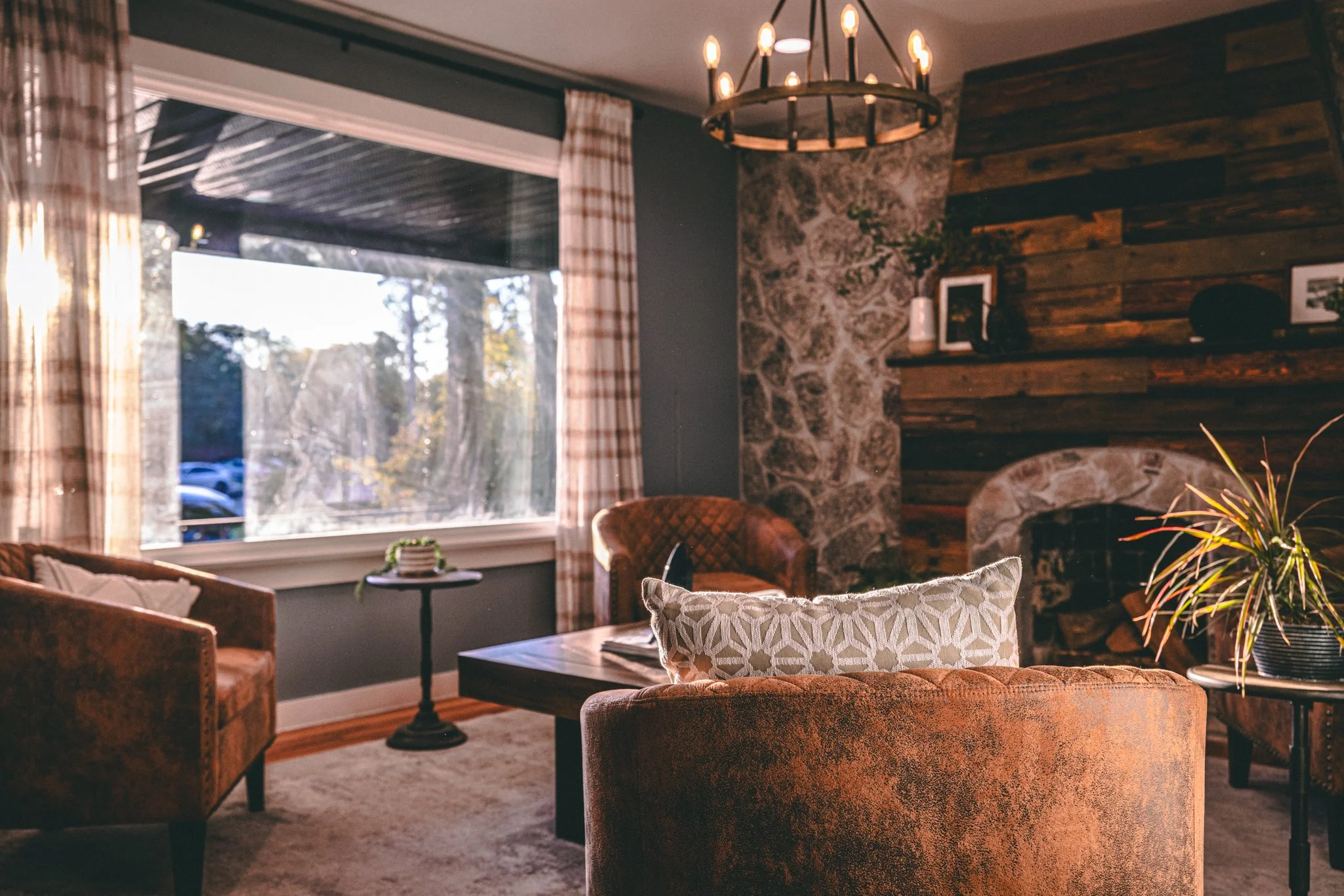 Wood-clad fireplace with leather barrel chairs in office lobby