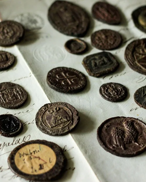 This is a selection of mostly medieval wax seal impressions that have browned over the years. Many of the seals depicted symbols and motifs related to their owner's profession, for example the scissors. 
