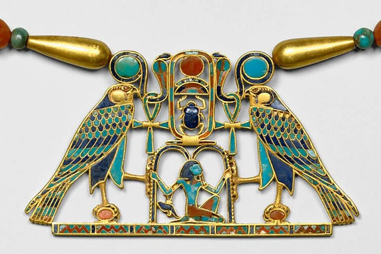 An elaborate cloisonné Egyptian falcon pectoral with semi-precious stones. It resides at the Met musuem in NYC and according to their website the design is composed around the throne name of King Senwosret II. Middle Kingdom. Gold, carnelian, lapis l
