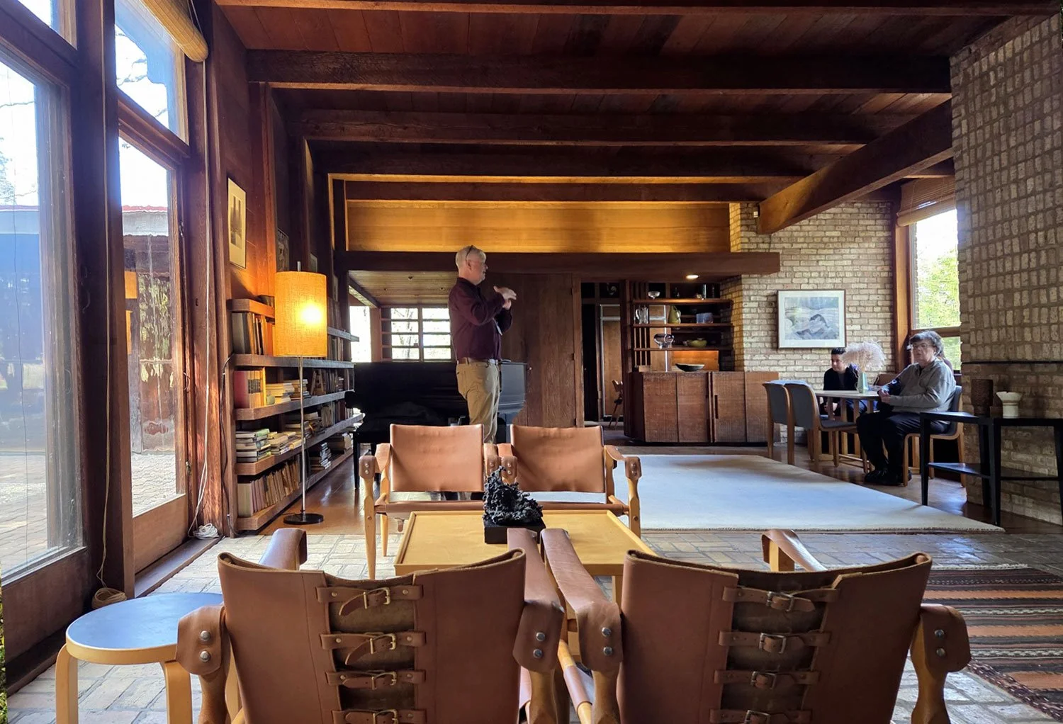View from the main room of Schweikher House that looks toward a dining nook and attached kitchen, all done in natural materials.