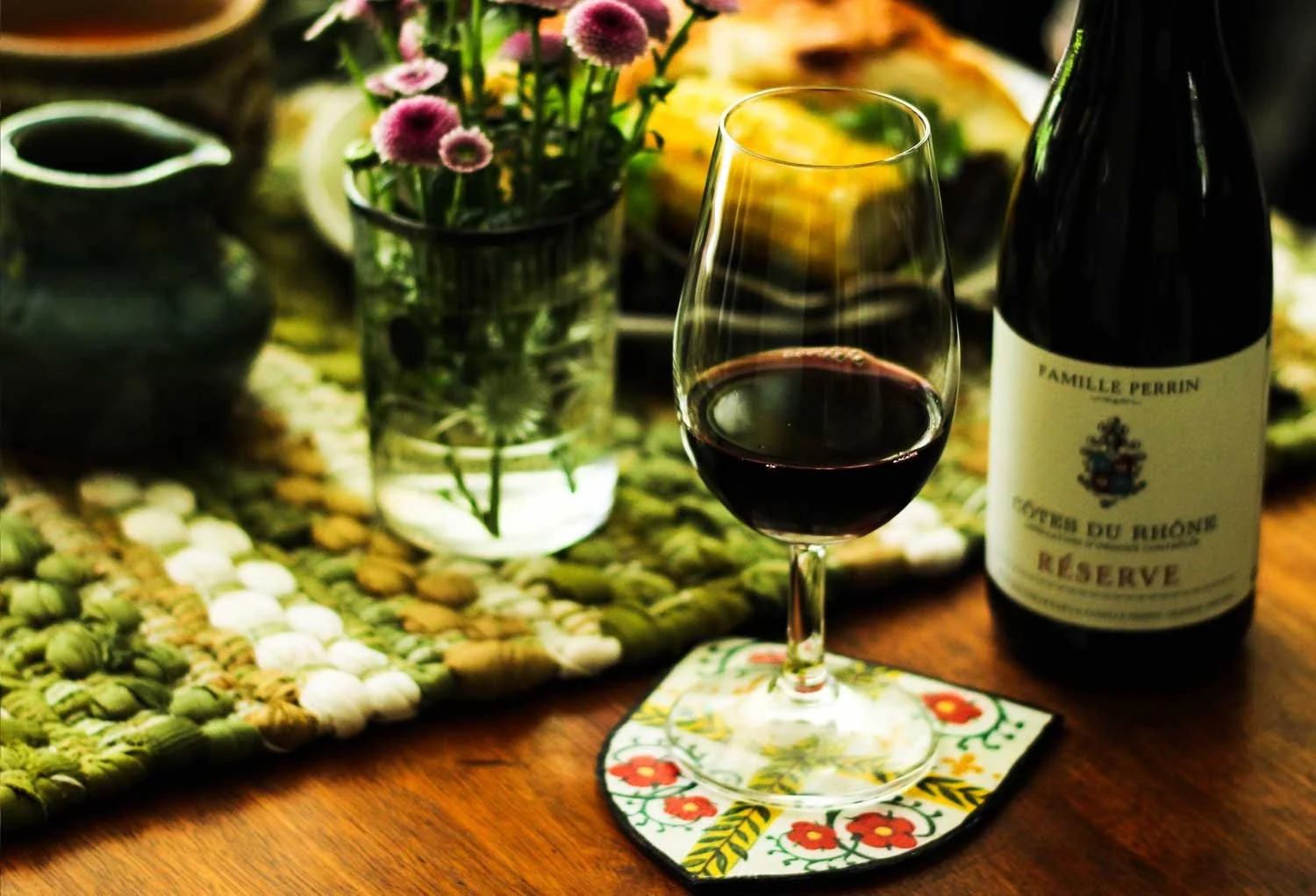 Wine glass on heraldic coaster.