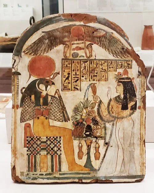 A funerary stela from a private tomb showing lady Djed-Khonsu-iw-es-ankh. She is seated across from god Re-Horakhty, a form of the sun god.