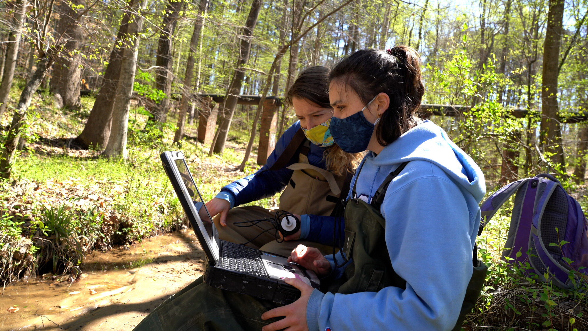  Farquhar (left) downloads data from a water sensor with Tessa Davis, another undergraduate researcher on the team. The data is also being collected and compared to local bio-retention ponds to determine whether beaver dams offer a cheaper alternativ