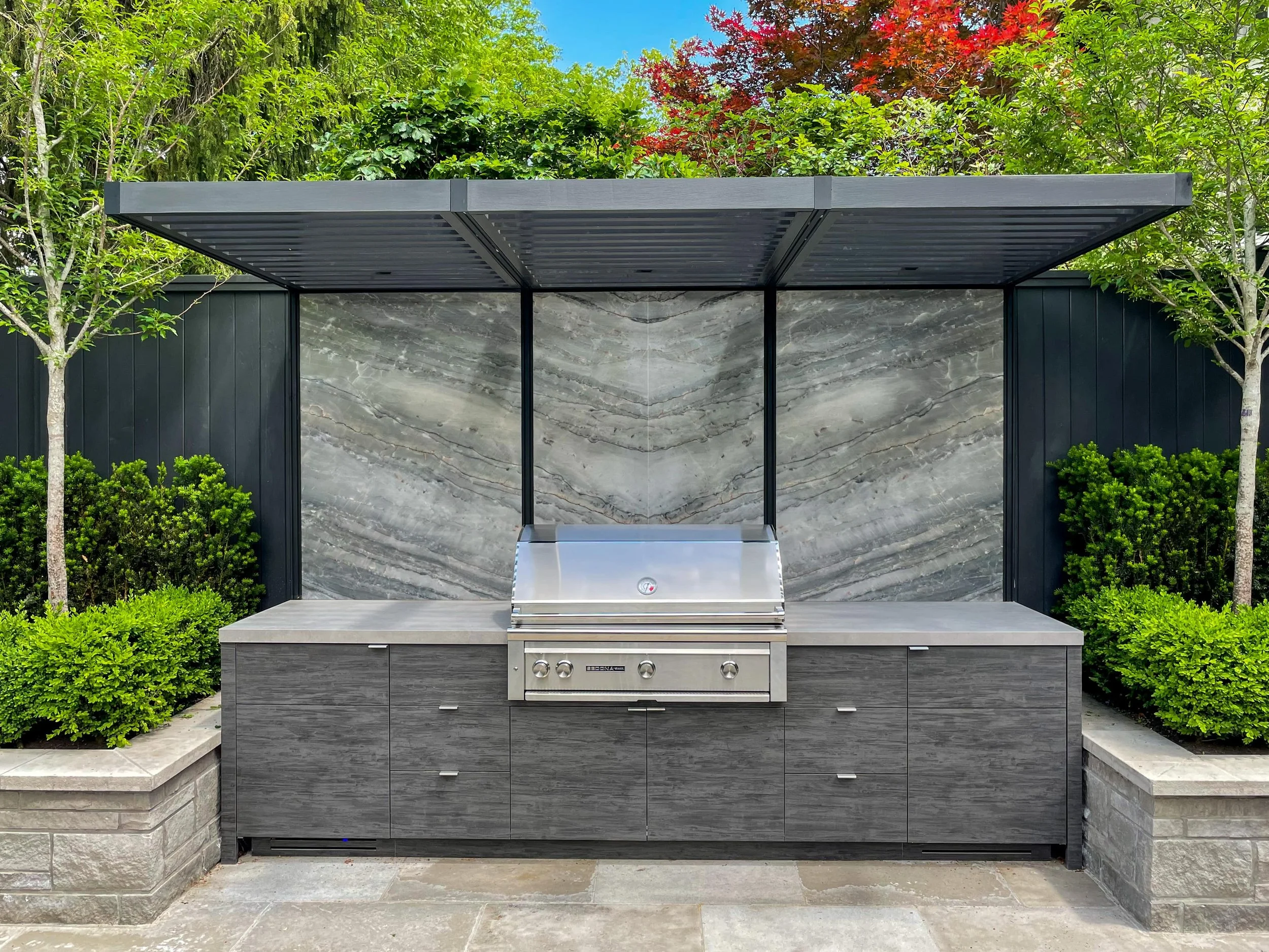outdoor-pergola-stone-backsplash-grey-wood-cabinetry.jpg