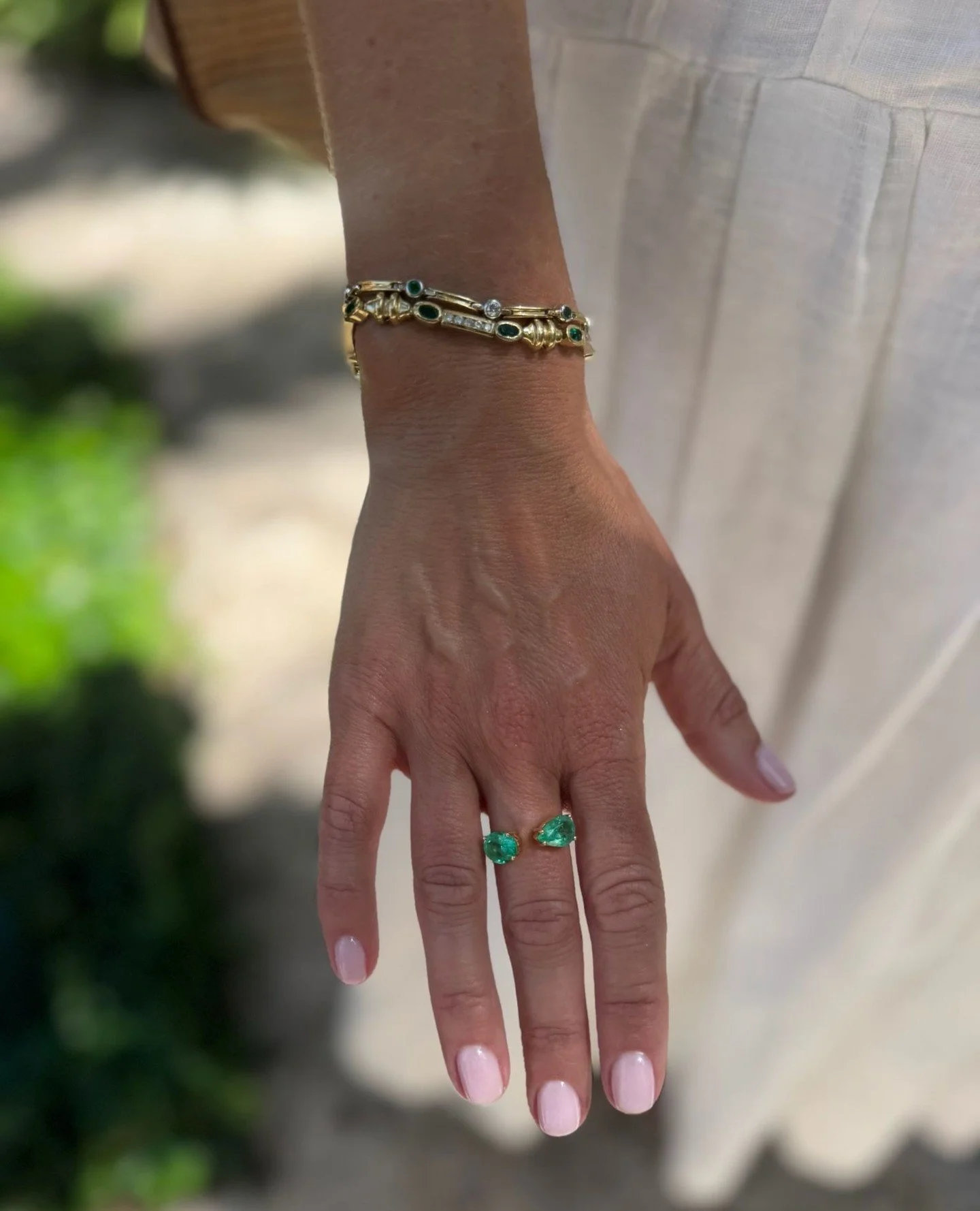 Green for spring! A unique and very eye catching pair of emeralds set slightly apart from one another in simple prong set mounts around a beaded 18KT gold shank.