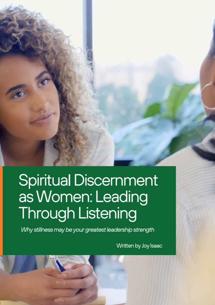 A woman with curly blonde hair and a neutral expression, sitting at a table and holding a pen. She is engaged in a conversation with another person partially visible on the right, in a bright room with large windows and green plants in the background. Overlaid text reads 'Spiritual Discernment as Women: Leading Through Listening' and 'Why stillness may be your greatest leadership strength,' written by Joy Isaac.