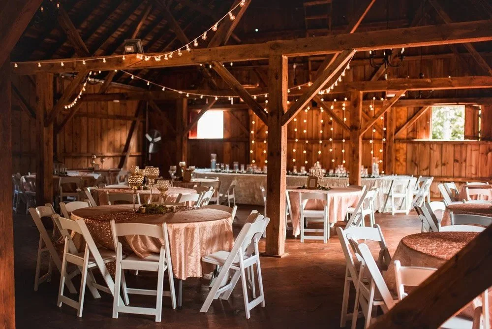 Wedding reception tables with elegant linens and décor inside JR’s Barn