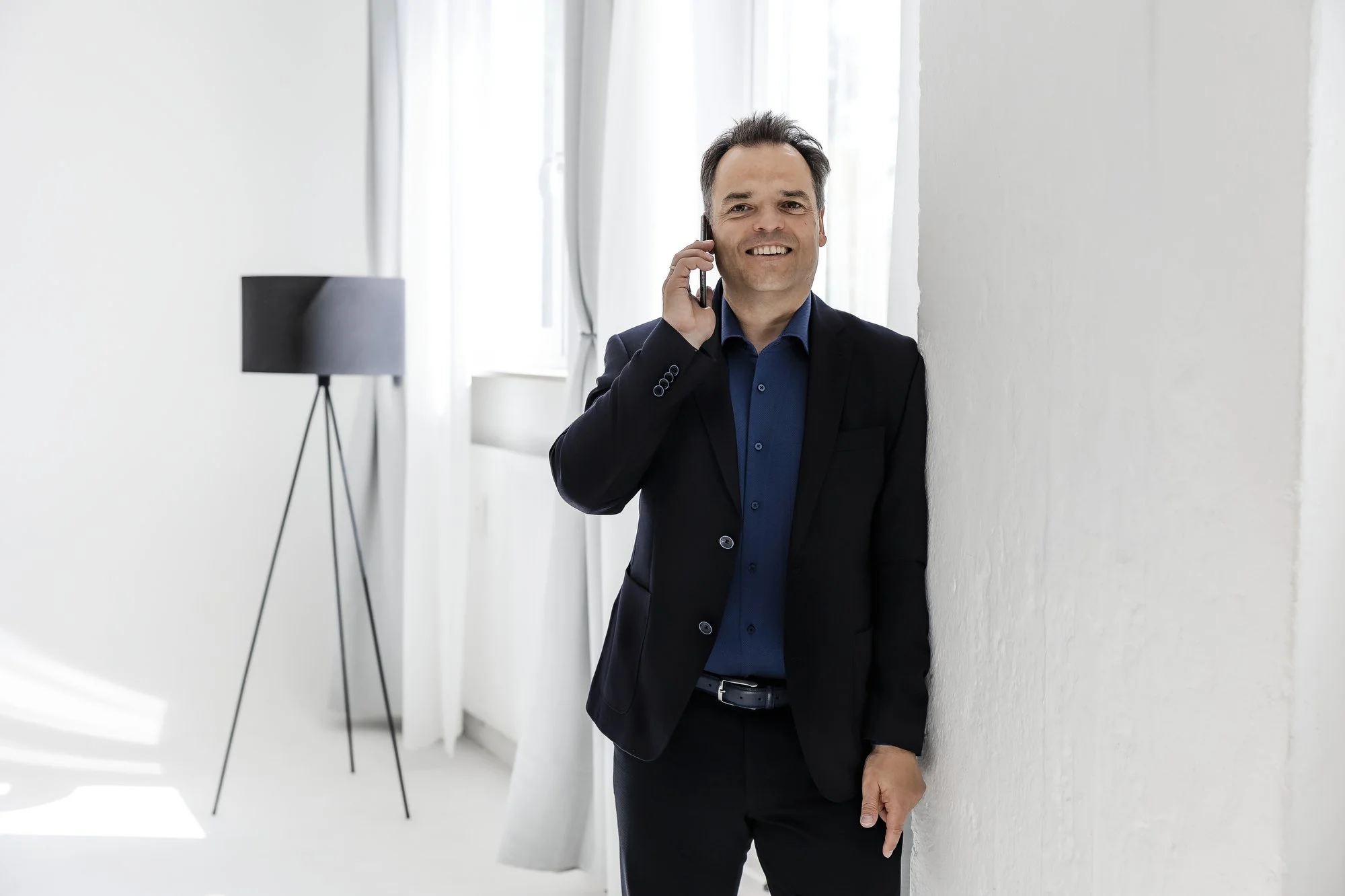 Business Portrait Hamburg – Unternehmensberater im Anzug telefoniert in modernem Büro.