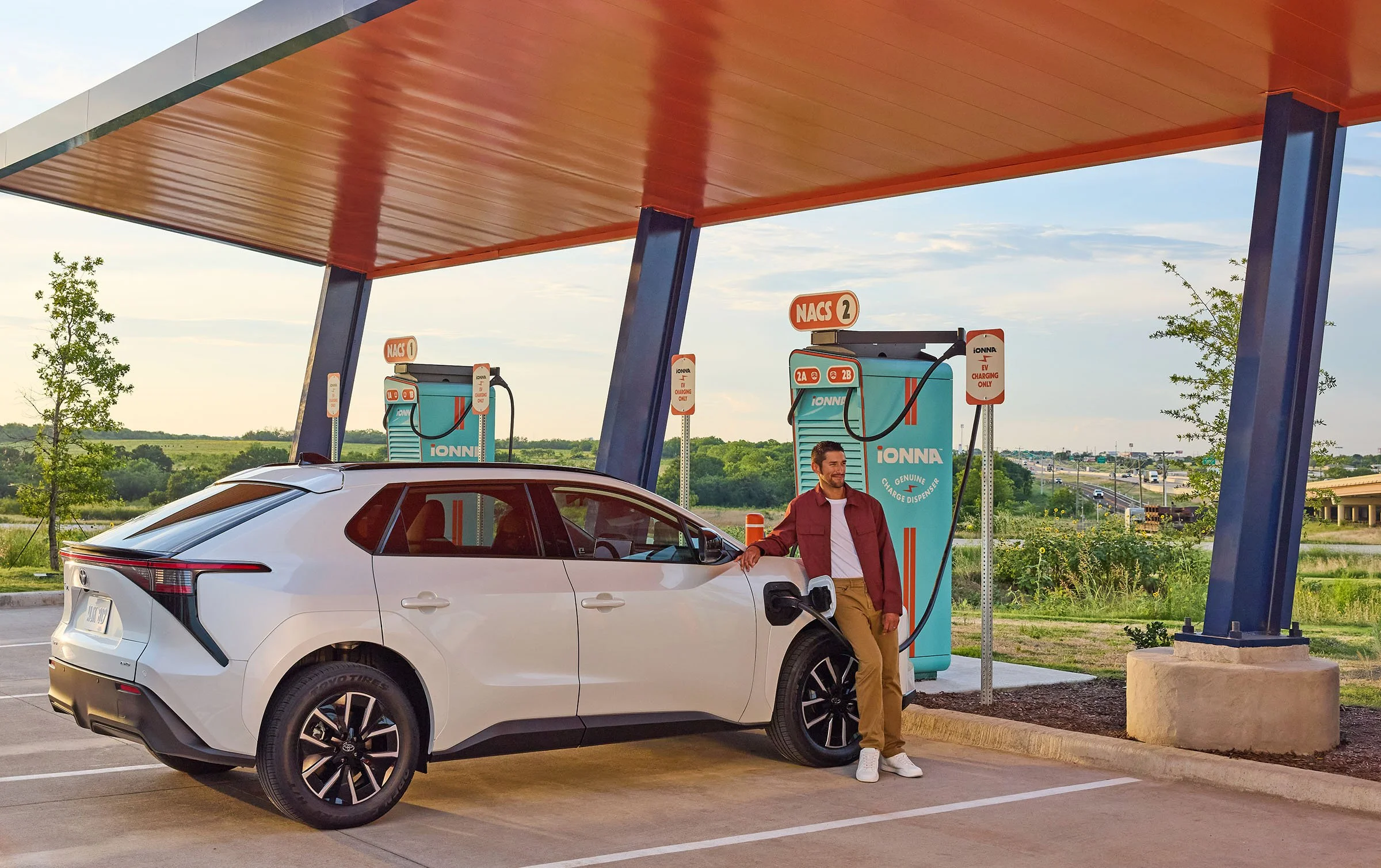 A man waits for his Toyota electric vehicle to charge. 