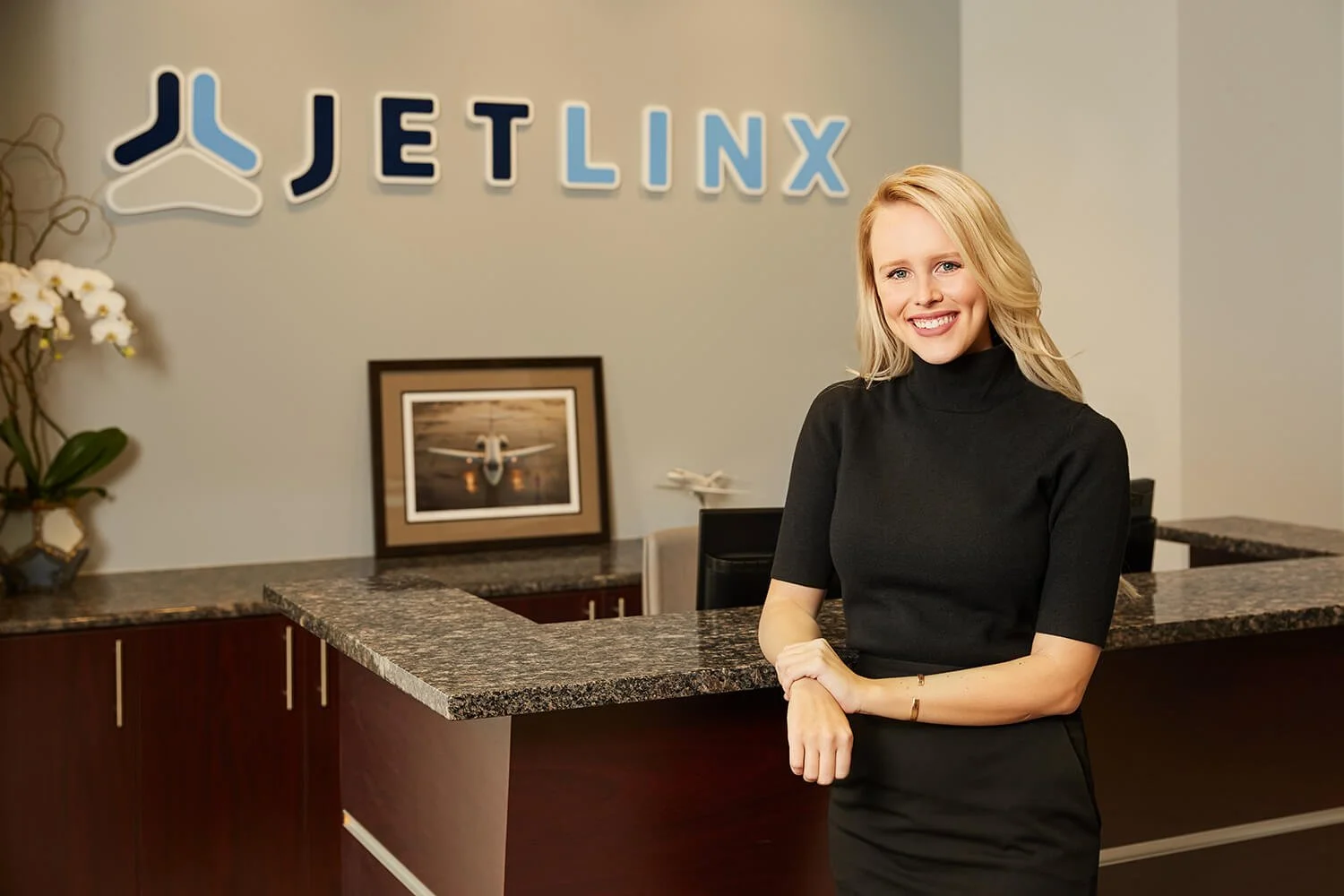 Woman standing at the Jet Linx office reception.