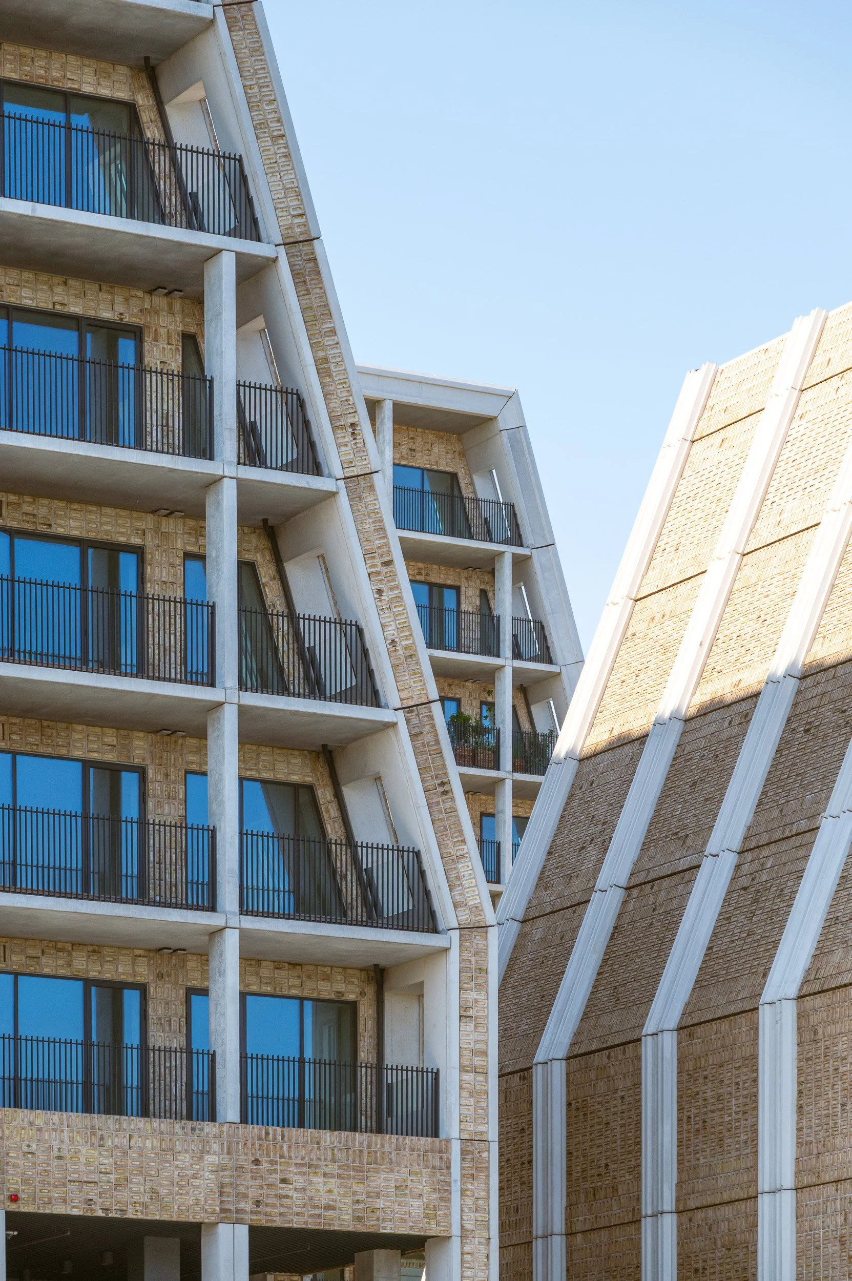 Color architectural detail capturing the sharp geometric angles, light brick facades, and leading lines of the modern structures on Papirøen in Copenhagen.