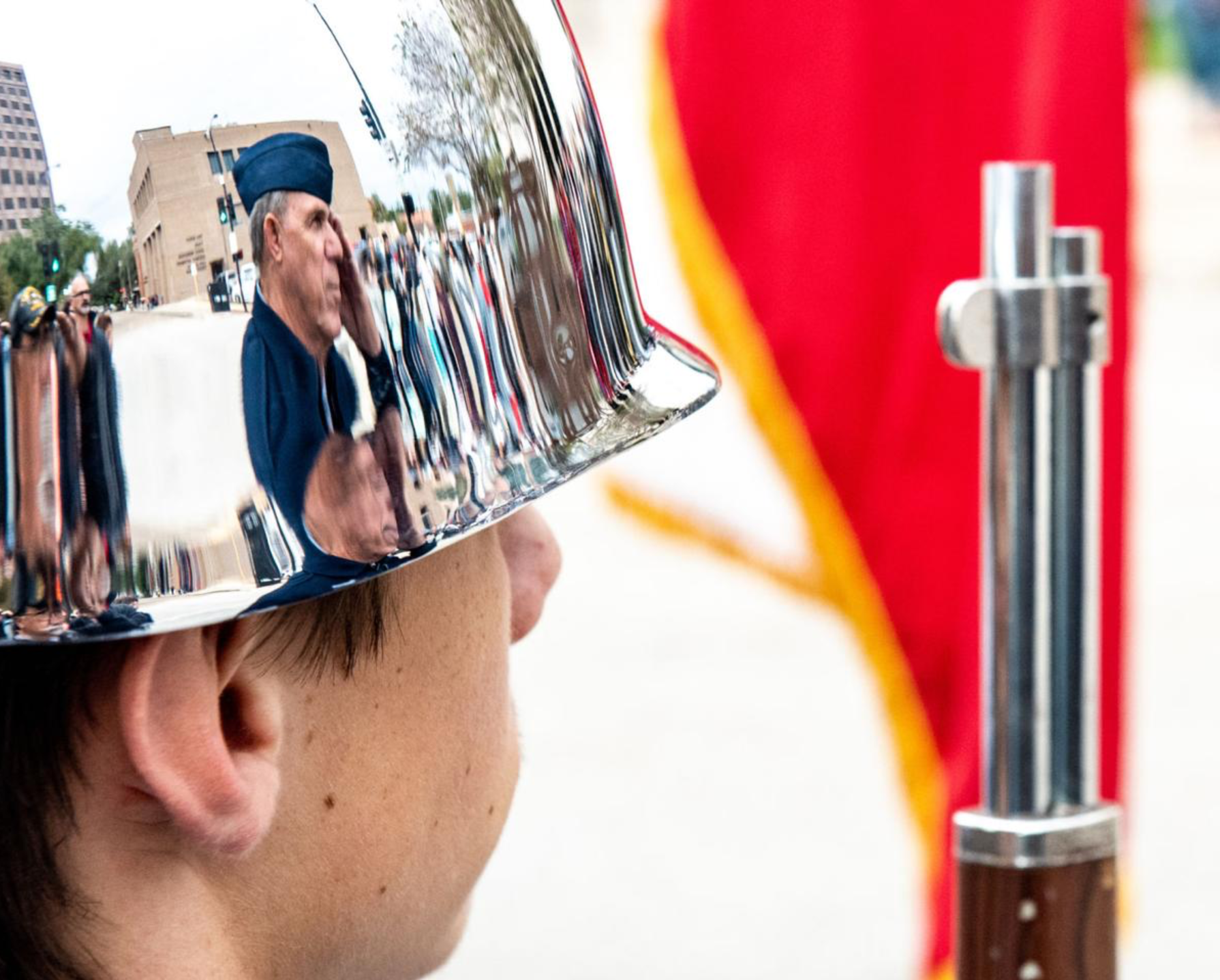 Master Sgt. John Miller is reflected in the helmet of Victoria West ROTC cadet Joseph Edds, 18, while the Bloomington High School marching band plays the national anthem at the Veterans Day parade in downtown Victoria.