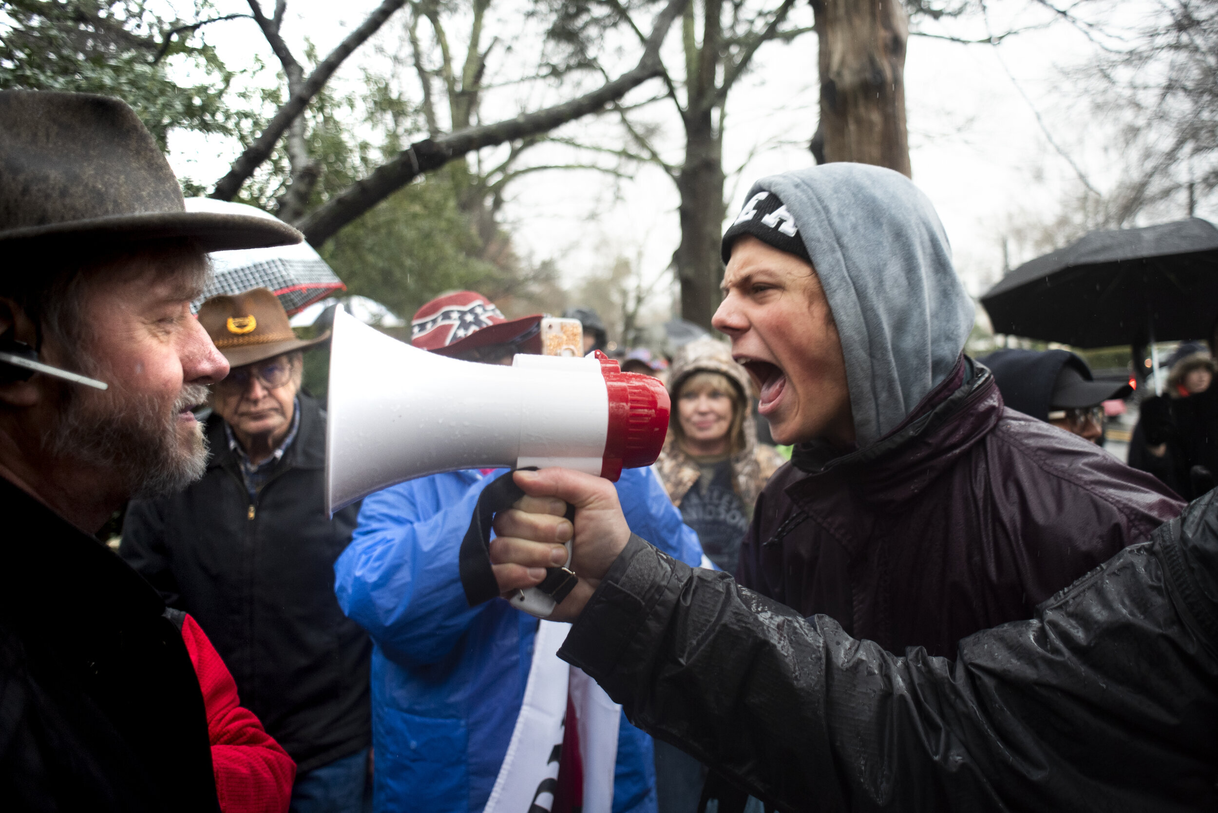 Outside the University of North Carolina at Chapel Hill, an anonymous counter-protestor recites anti-racism mantras through a megaphone, directed at Heirs to the Confederacy advocate Rusty Alphin. After learning of the February 23 pro-Confederate eve
