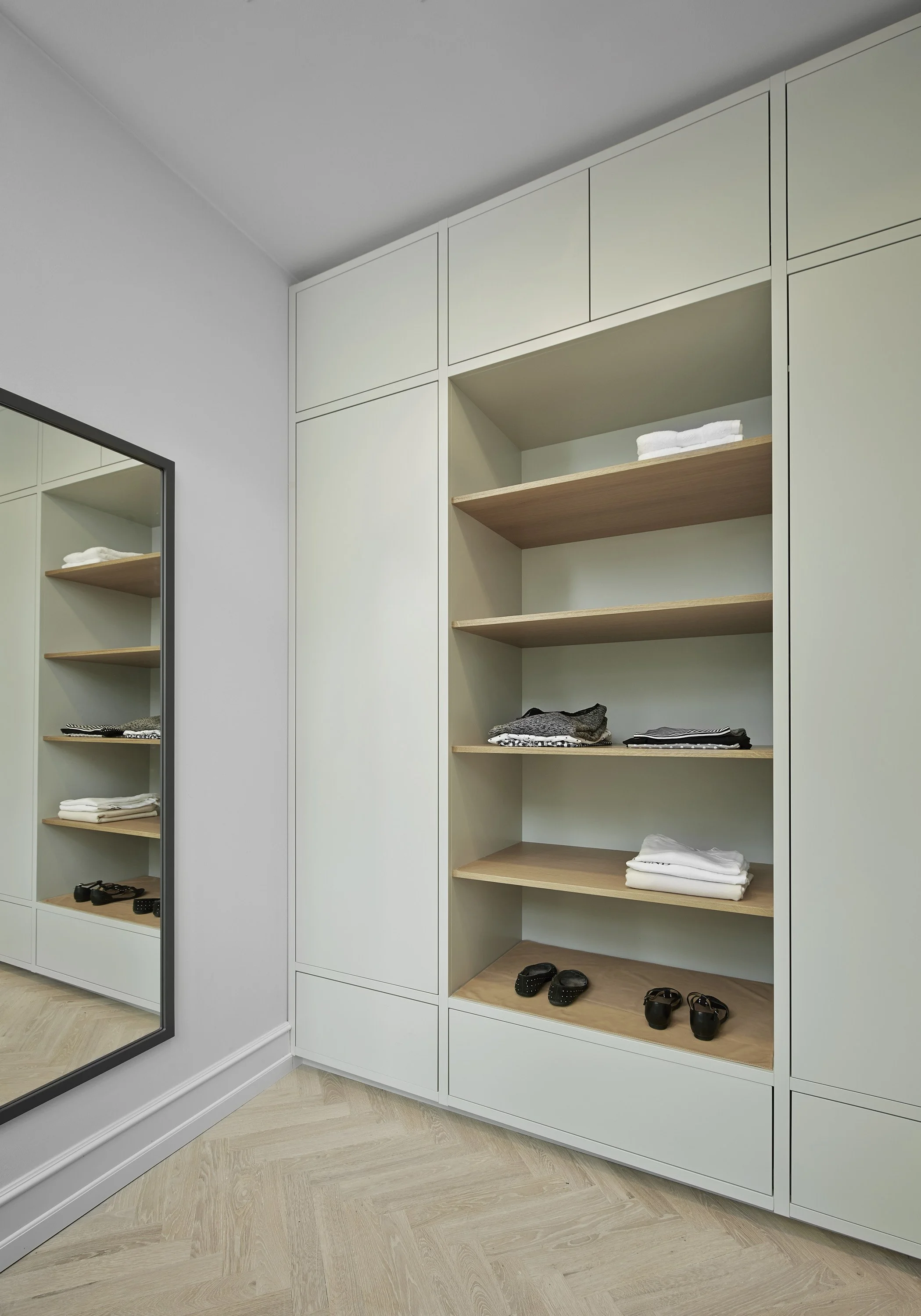 Spejl, garderobe med åbne hylder med tøj og sko i et moderne værelse.