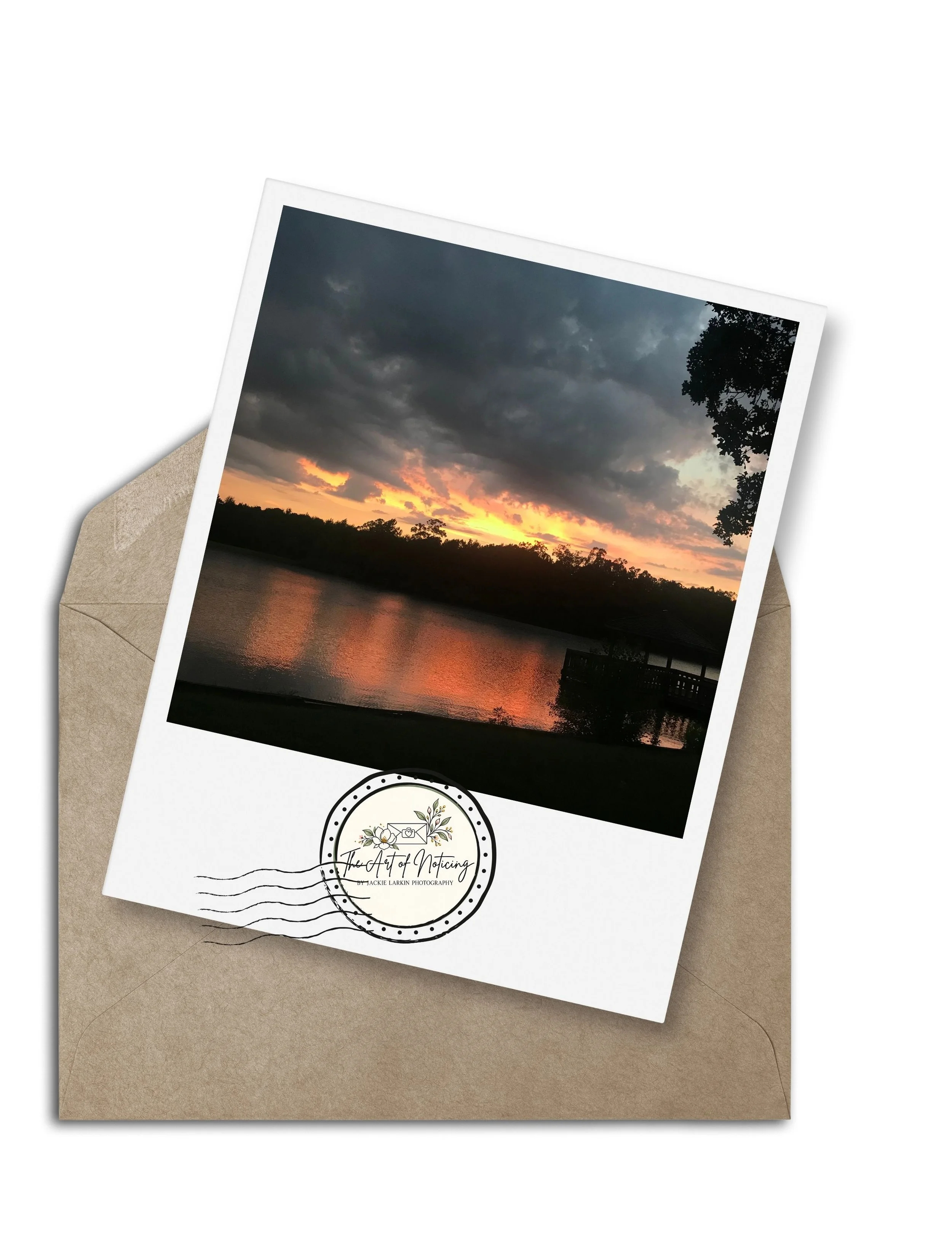 A poloraid photo on top of a brown envelope of the sun setting over a lake and reflecting off in Mississippi.