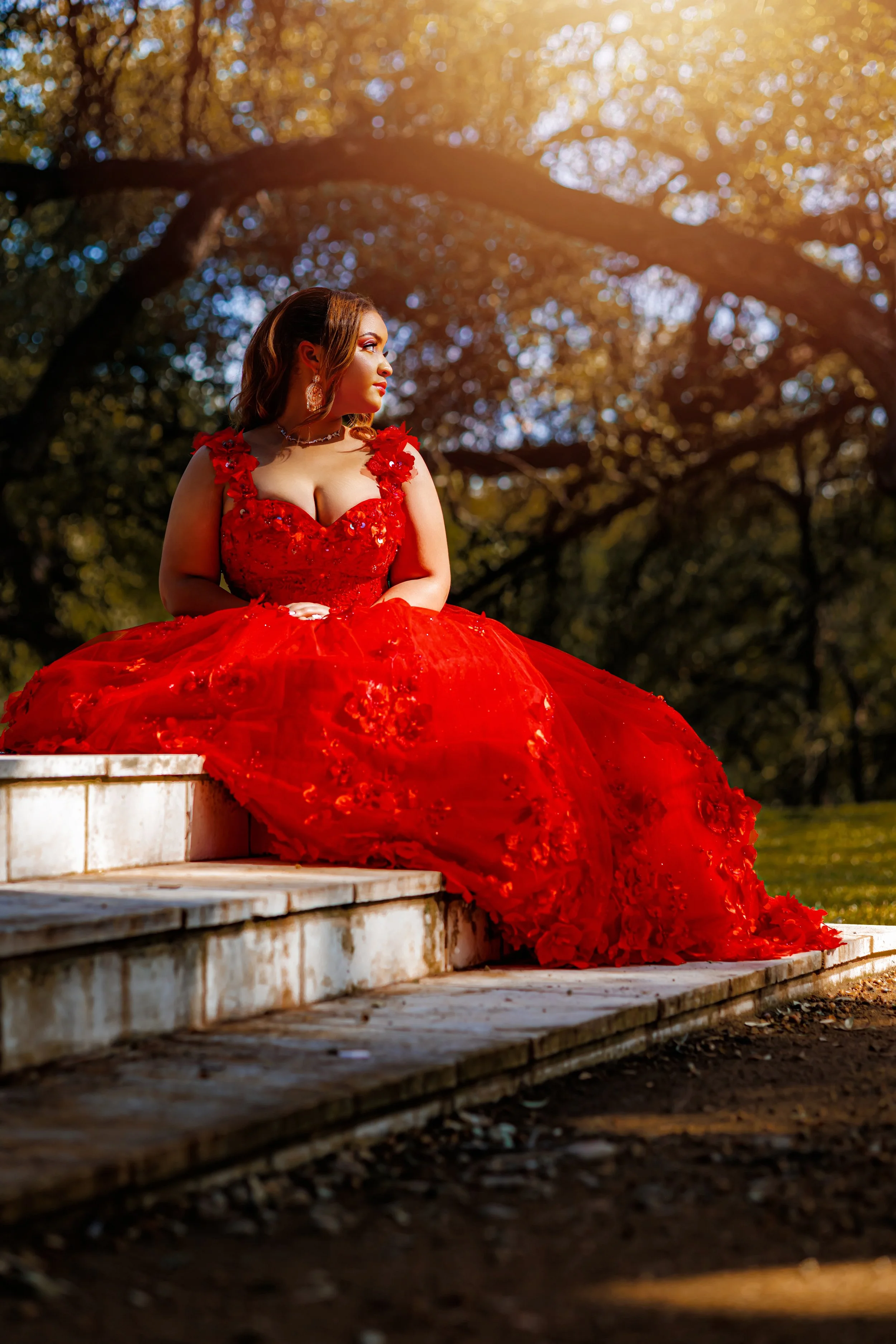 Young women celebrating her quinceanera in red formal gown during her traditional gathering.